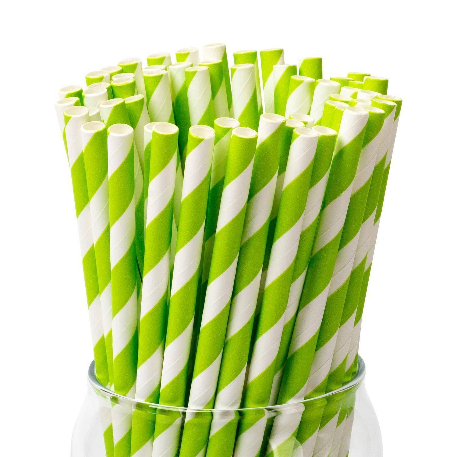 Glasgefäß gefüllt mit grün und weiß gestreiften Papiertrinkhalmen auf weißem Hintergrund.