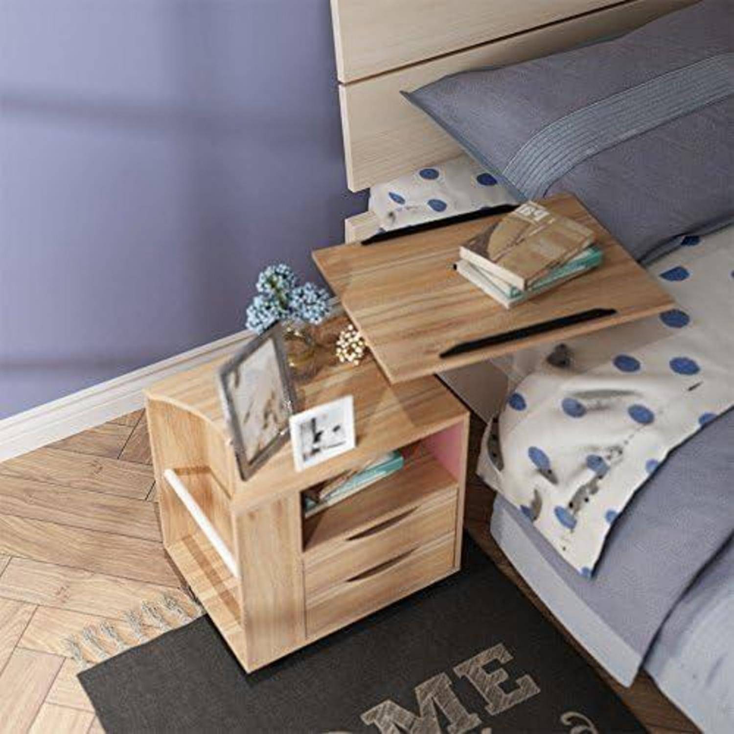 Nachttisch aus Holz neben dem Bett mit ausziehbarem Tablett, das Bücher und einen Stift hält, neben einem Bett mit grauer Bettwäsche mit Punktmuster