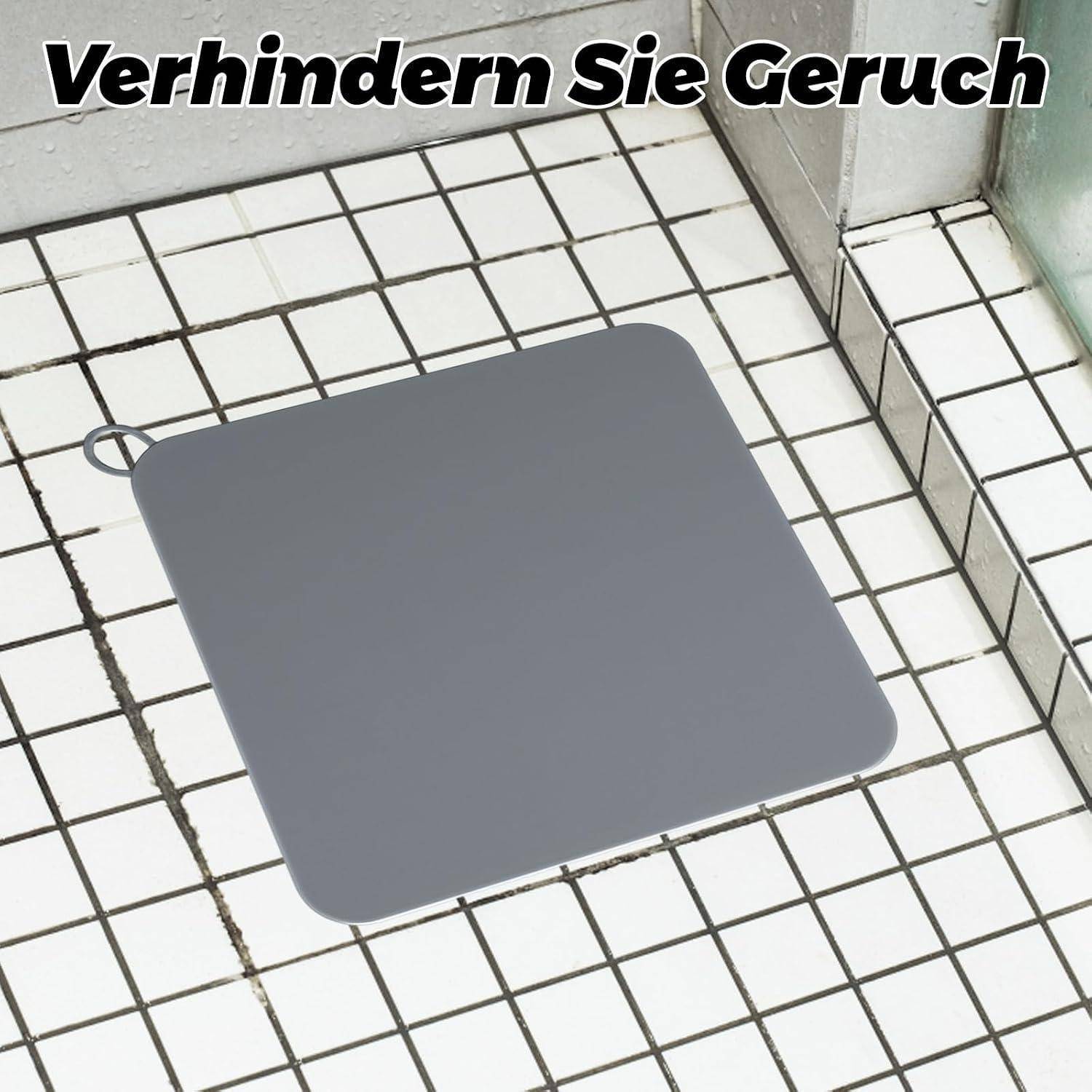 Quadratische graue Abdeckung auf einem gefliesten Duschboden mit deutschem Text „Verhindern Sie Geruch