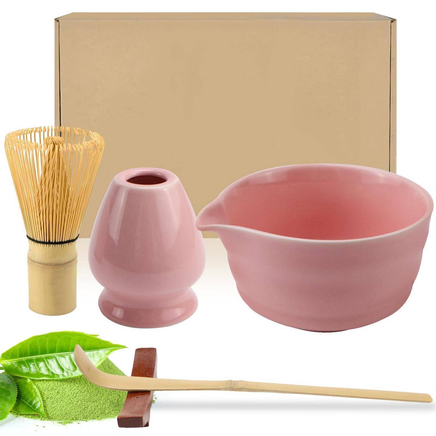 Satz von Teezeremonie-Werkzeugen: Pappschachtel, Bambusbesen, rosa Teebehälter, rosa Mischschüssel, grünes Tuch, Blatt und Holzlöffel.