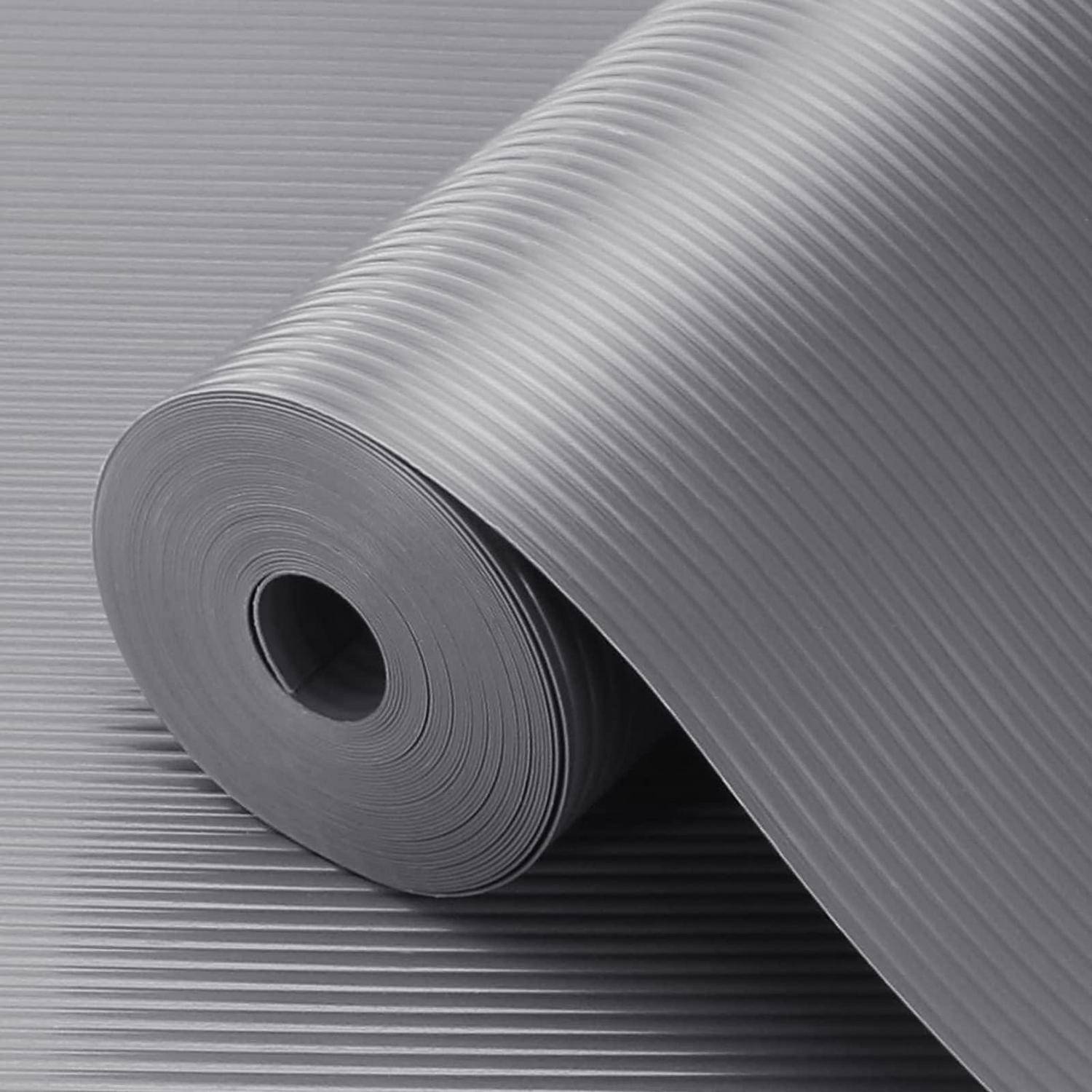 Eine große Rolle aus grauem Wellmaterial, mit einem Blatt, das über eine passende strukturierte Oberfläche ausgerollt ist.