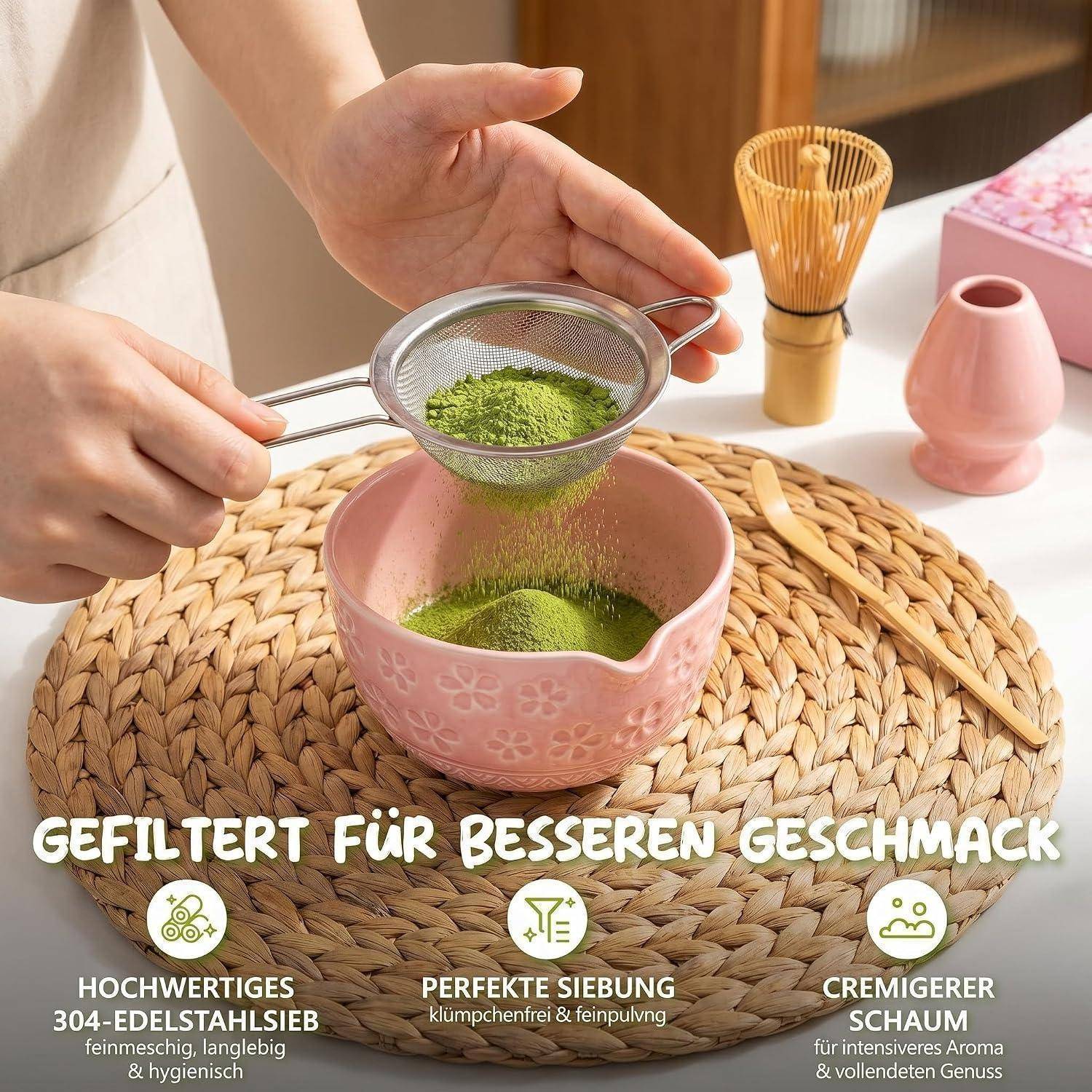 Hände sieben Matcha-Pulver in eine rosa Schüssel auf einer geflochtenen Matte, mit deutschem Text, der gefiltertes Tee für besseren Geschmack, feines Sieben und cremigeren Schaum bewirbt.