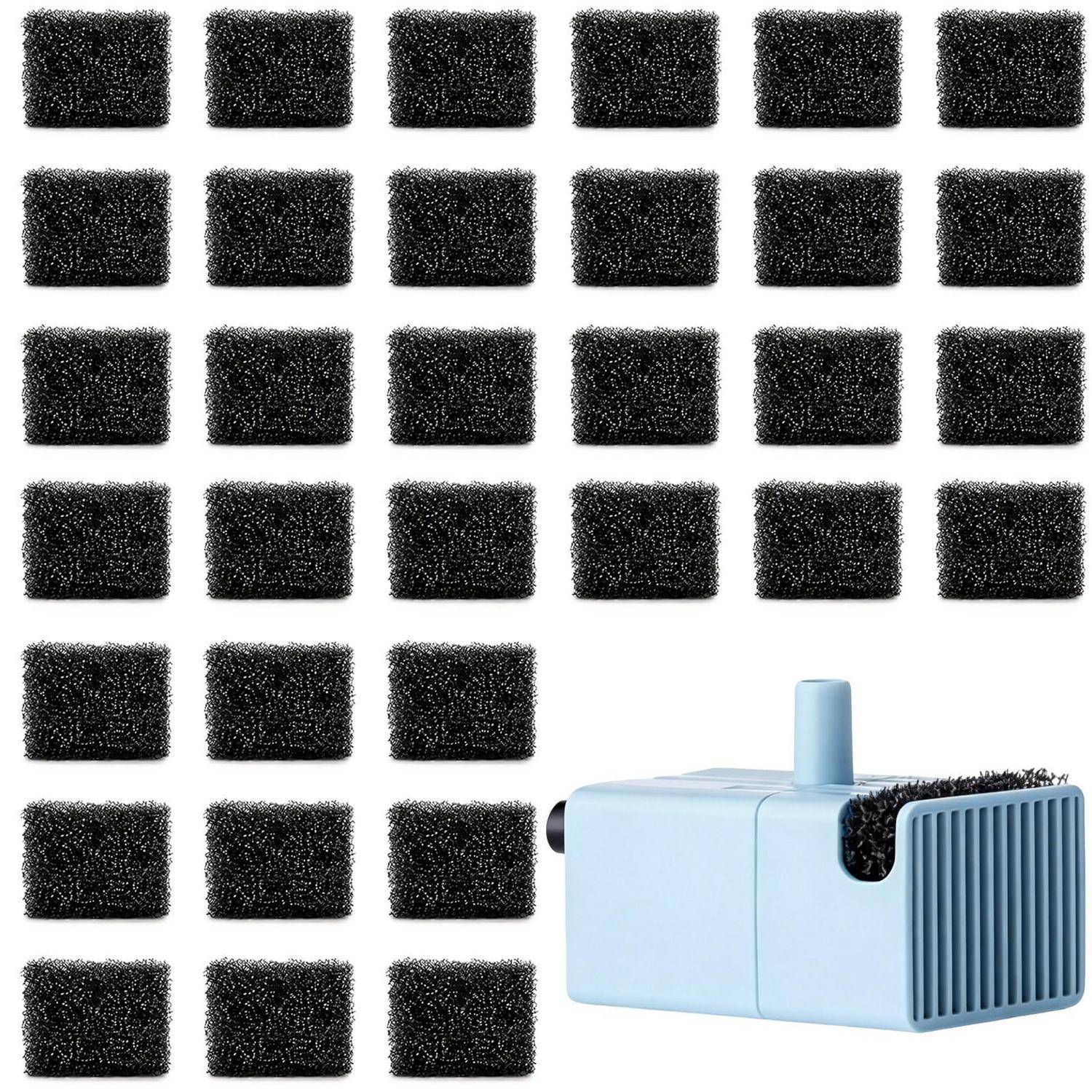 Ein kleiner blauer Luftreiniger mit einem vorderen Gitter und einem oberen Griff sitzt neben vielen schwarzen quadratischen Filterkissen, die in einem Gitter angeordnet sind.