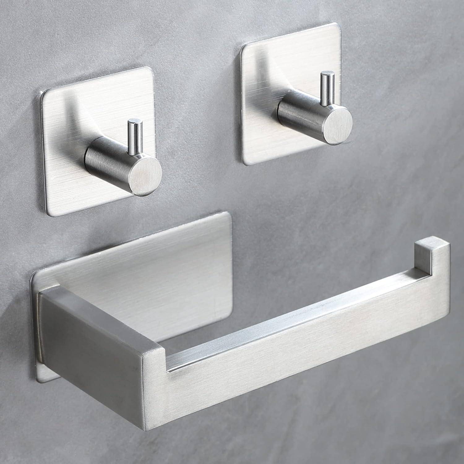 Gebürstetes Metall Badezimmer-Beschlagsatz: Handtuchstange unterhalb von zwei Wandhaken an einer grauen Wand.