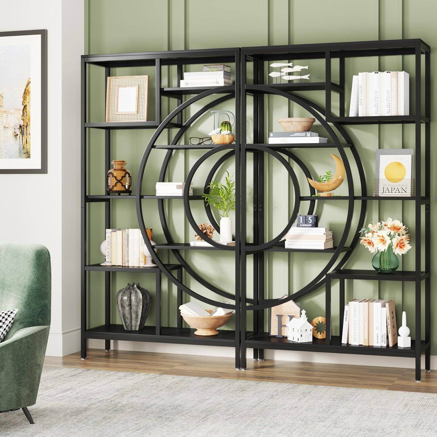 Schwarzes Metallbücherregal mit kreisförmigem geometrischem Mittelpunkt, gestaltet mit Büchern, Pflanzen, Vasen und Dekoration vor einer grünen Wand in einem Wohnzimmer.