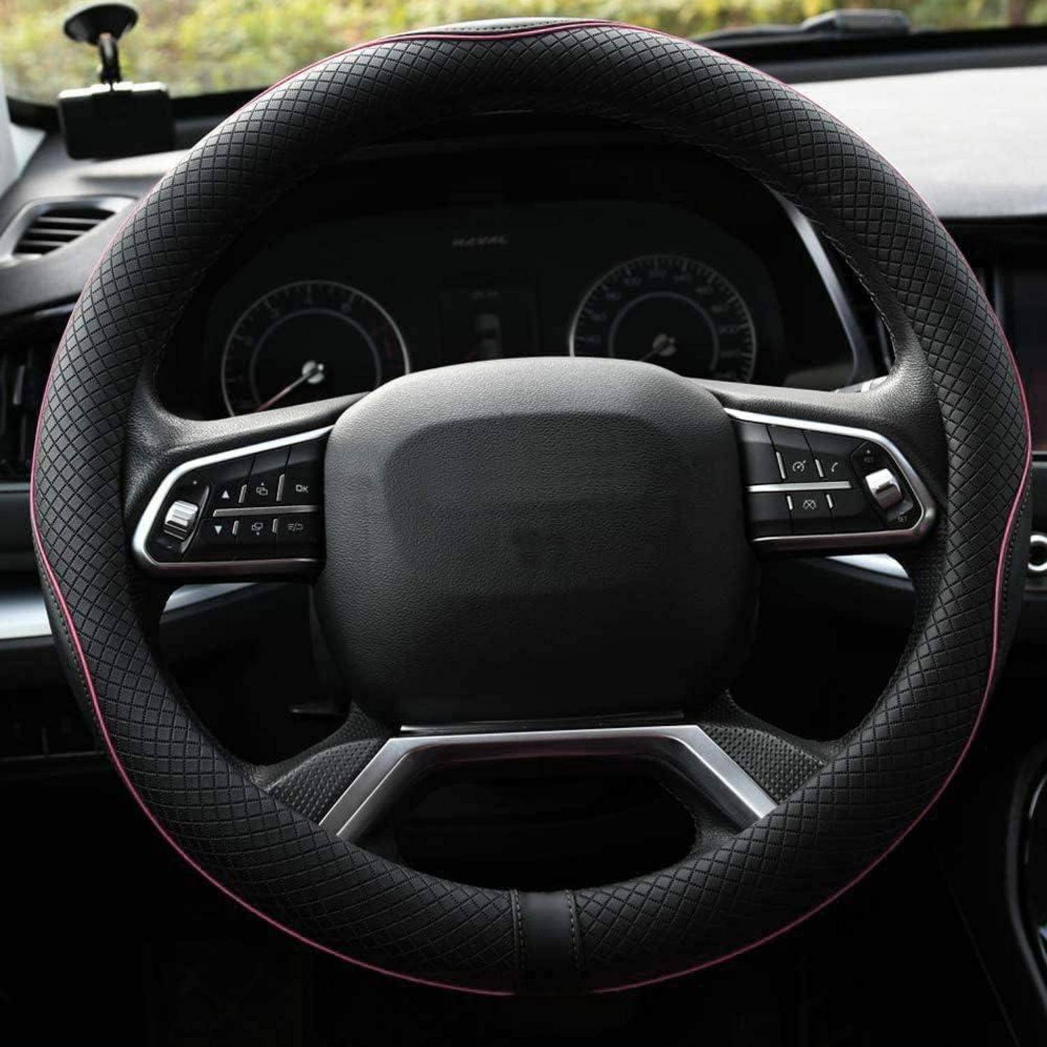 Nahaufnahme eines Auto-Lenkrads mit integrierten Bedientasten und digitalen Instrumenten dahinter.