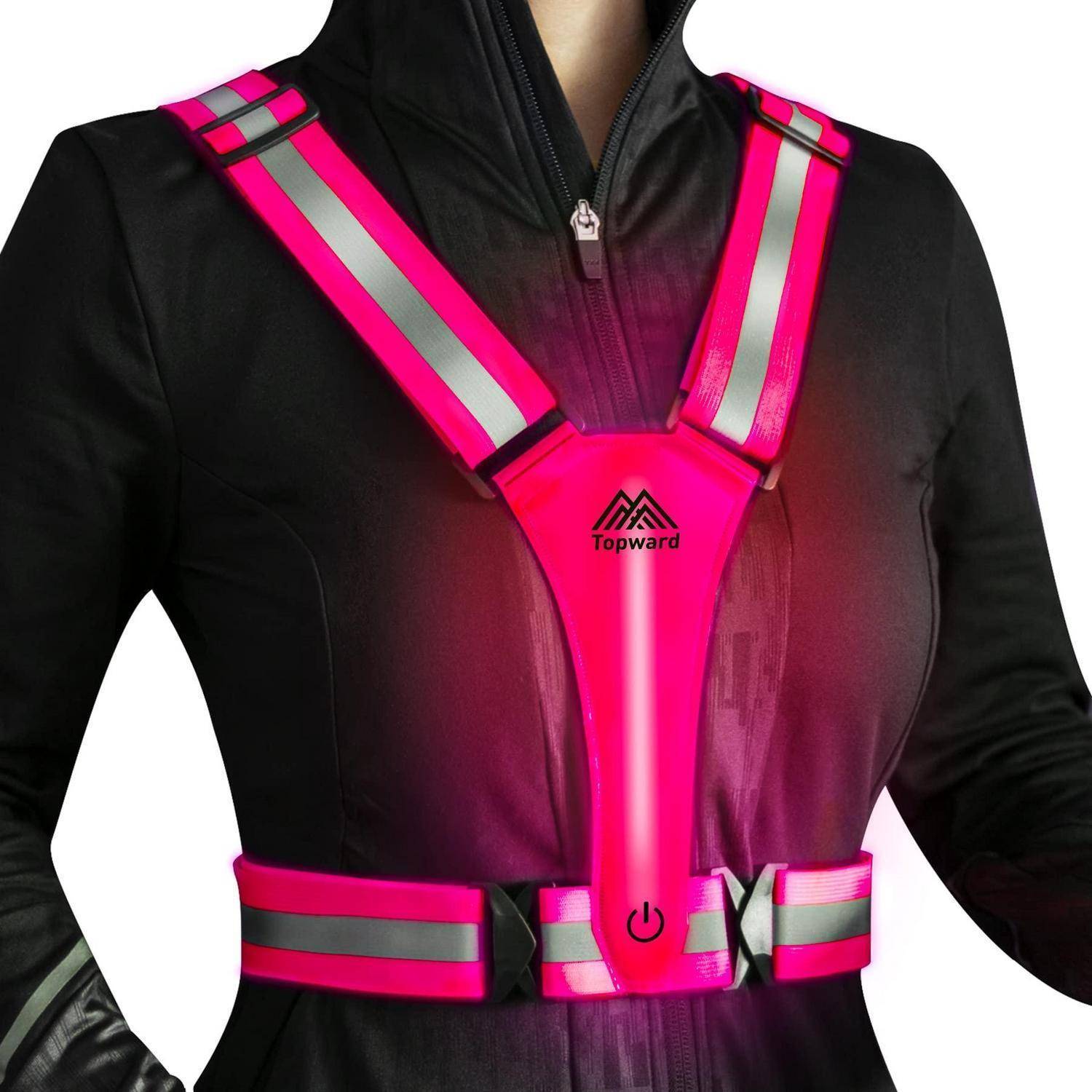 Person, die eine schwarze Jacke mit leuchtend rosa reflektierenden LED-Sicherheitsstreifen und Gürtel trägt, mit einer zentrierten Stromtaste und dem Logo 
