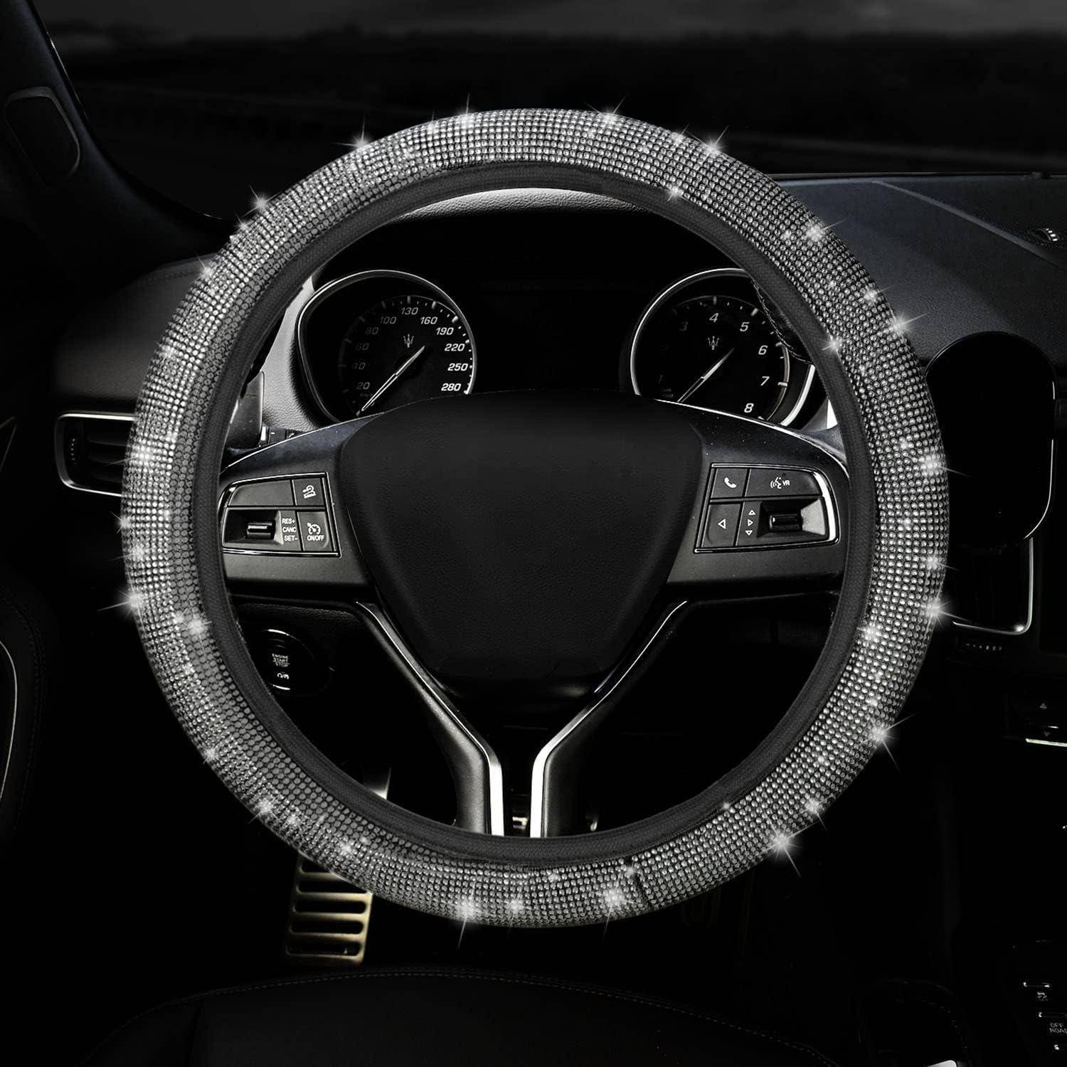 Nahaufnahme eines Autolenkrads mit glitzerndem Strass-Bezug und Armaturenbrett-Anzeigen dahinter.