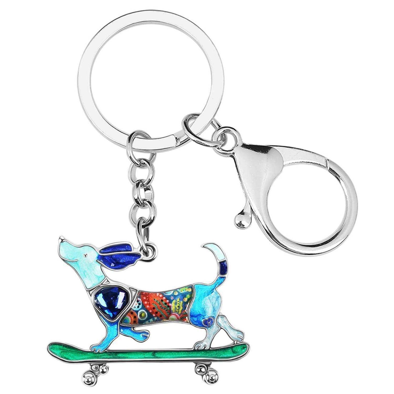 Silberner Schlüsselanhänger mit einem bunten Hund auf einem Skateboard-Charm und einer Hummerklammer auf weißem Hintergrund.