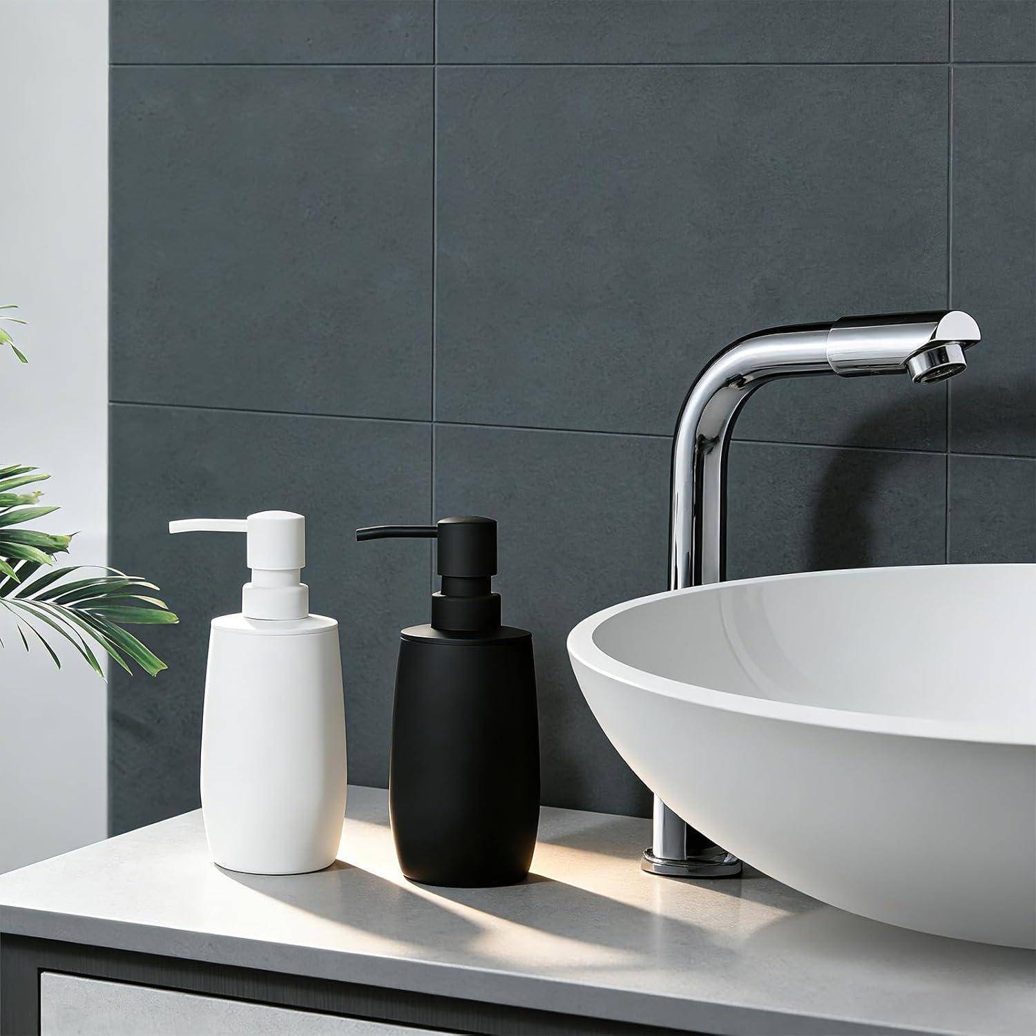 Modernes Badezimmerbecken mit einem Chromwasserhahn und zwei Seifenspendern, einem weißen und einem schwarzen, auf einer hellen Arbeitsplatte.