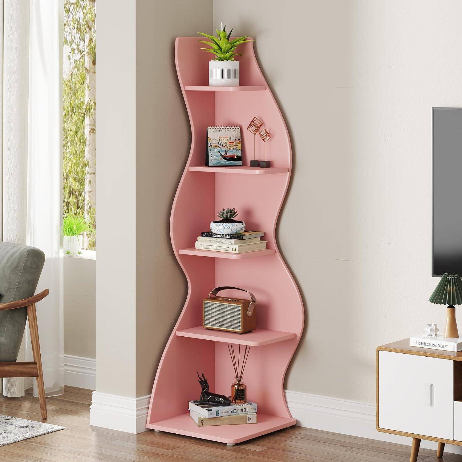 Rosa gewelltes Eckbücherregal mit fünf Regalbrettern, die Pflanzen, Bücher, Dekorationsgegenstände und einen kleinen Lautsprecher in einem hellen Wohnzimmer hält.