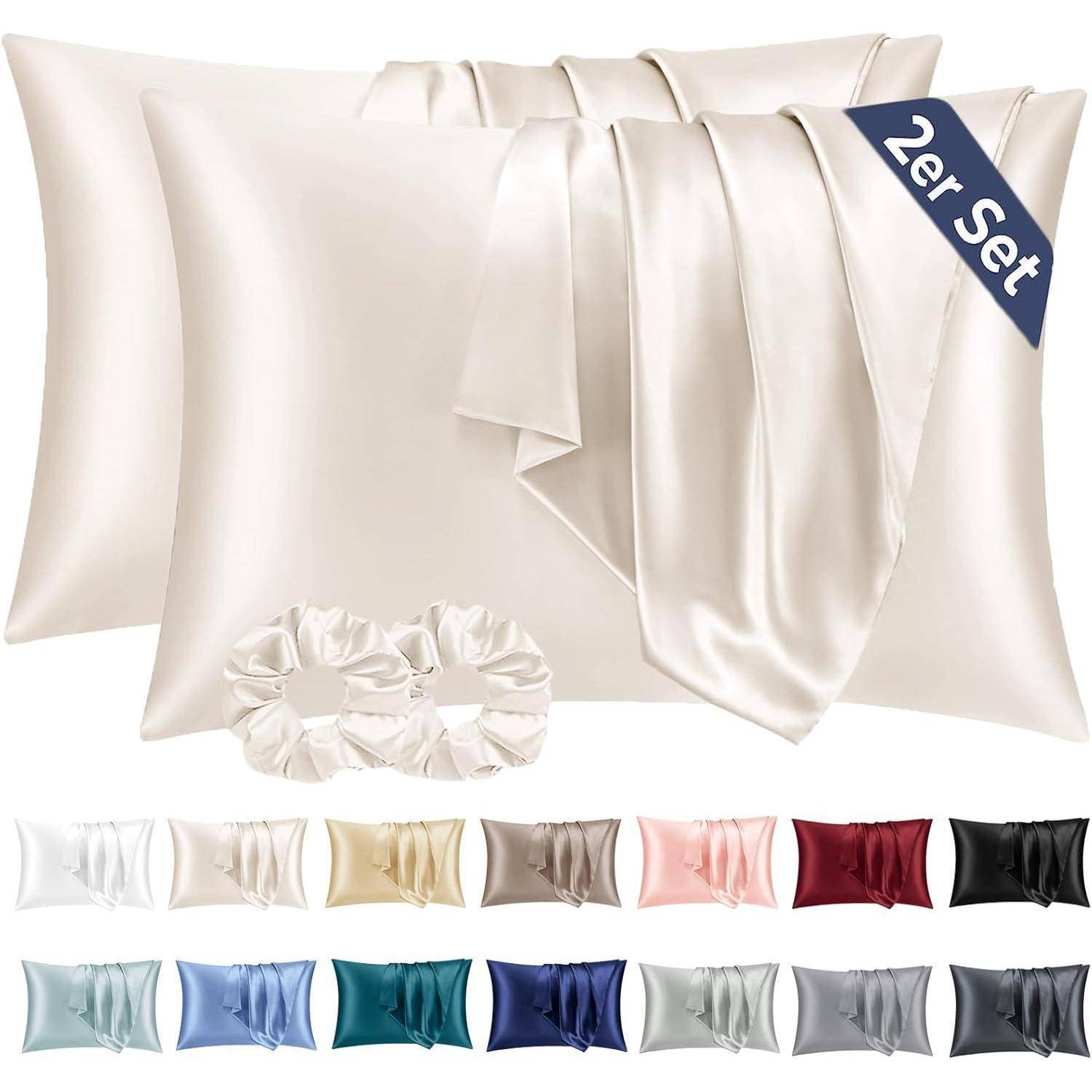 Set aus Satinkissenbezügen mit passendem Schlafmaske, gezeigt in Creme; das Etikett liest „2er Set