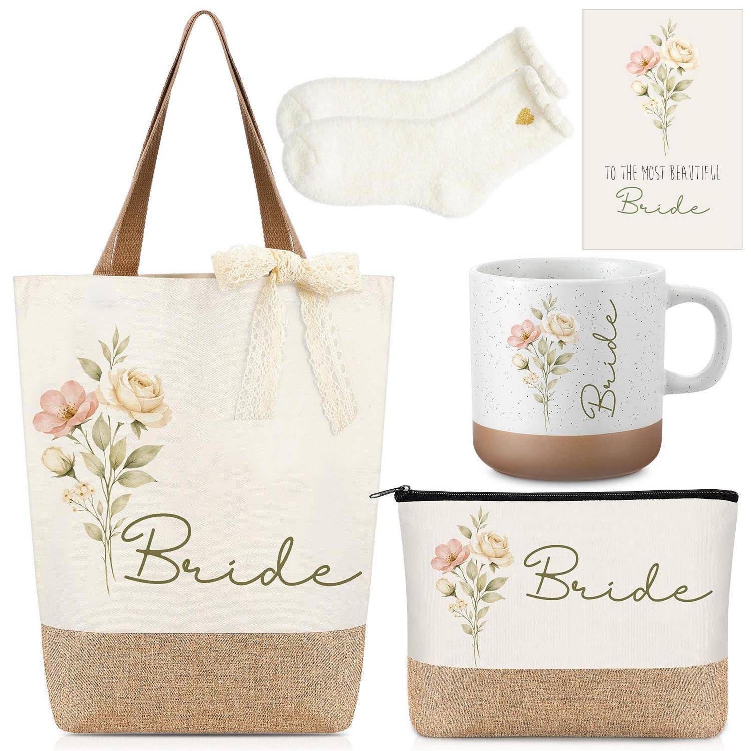 Brautgeschenkset mit blumiger 'Bride' Tragetasche, Tasse, Reißverschlussbeutel, Socken und Karte auf weißem Hintergrund.