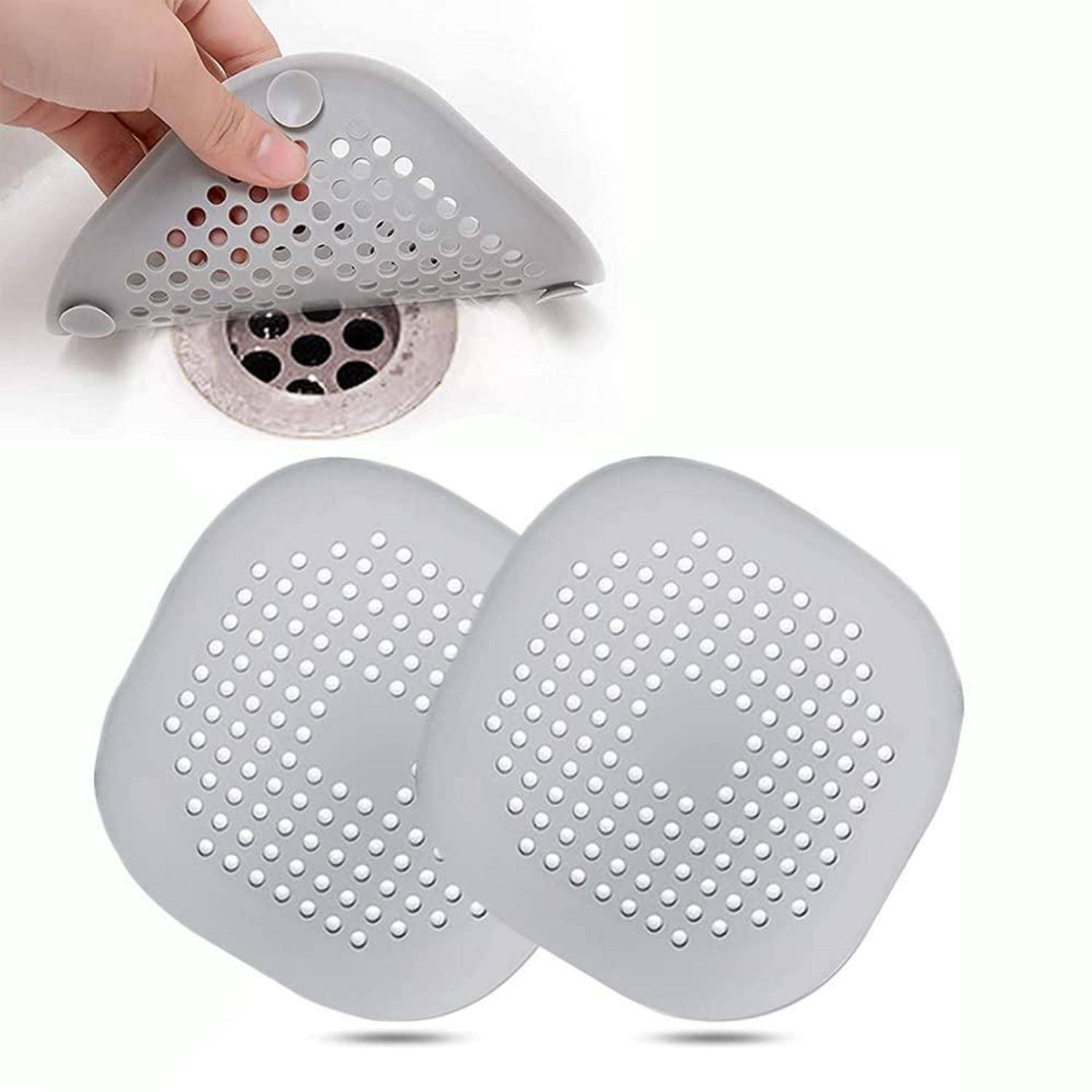 Graue Silikonablaufabdeckung mit Perforationen, die über einem Duschablauf gezeigt wird, plus zwei Abdeckungen, die darunter angezeigt werden.