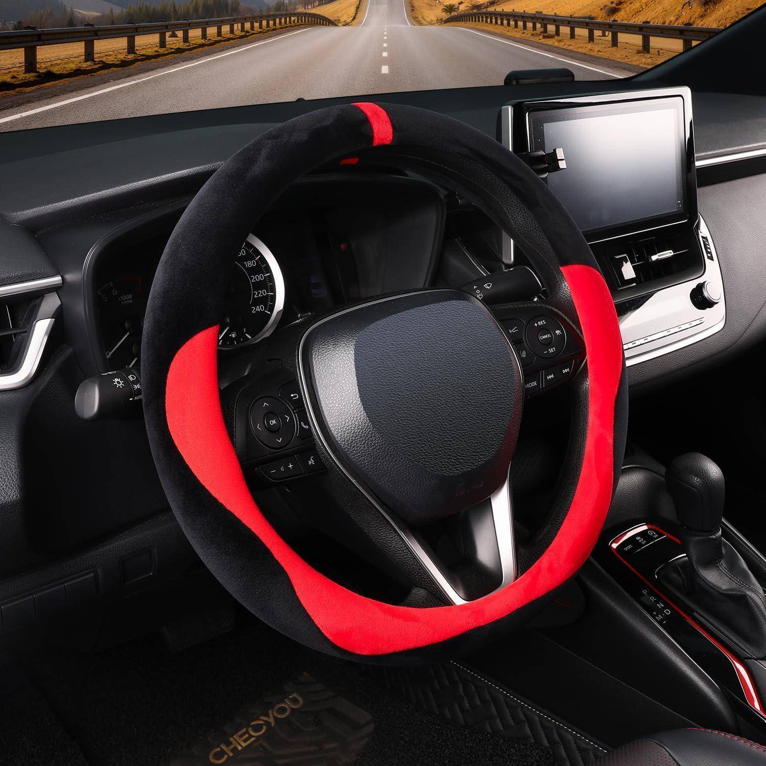 Automobilinneres mit einer rot-schwarzen Lenkradbezug, Armaturenbrett-Display und die Straße vor uns ist durch die Windschutzscheibe sichtbar.