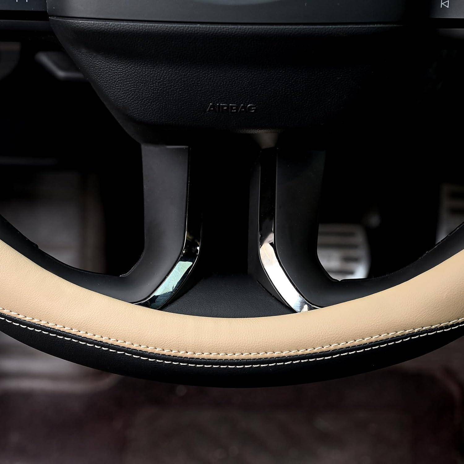 Nahaufnahme eines Autolenkrads mit beigem Lederbezug und Chromakzenten, die die untere Mitte in der Nähe der Airbag-Nabe zeigt.