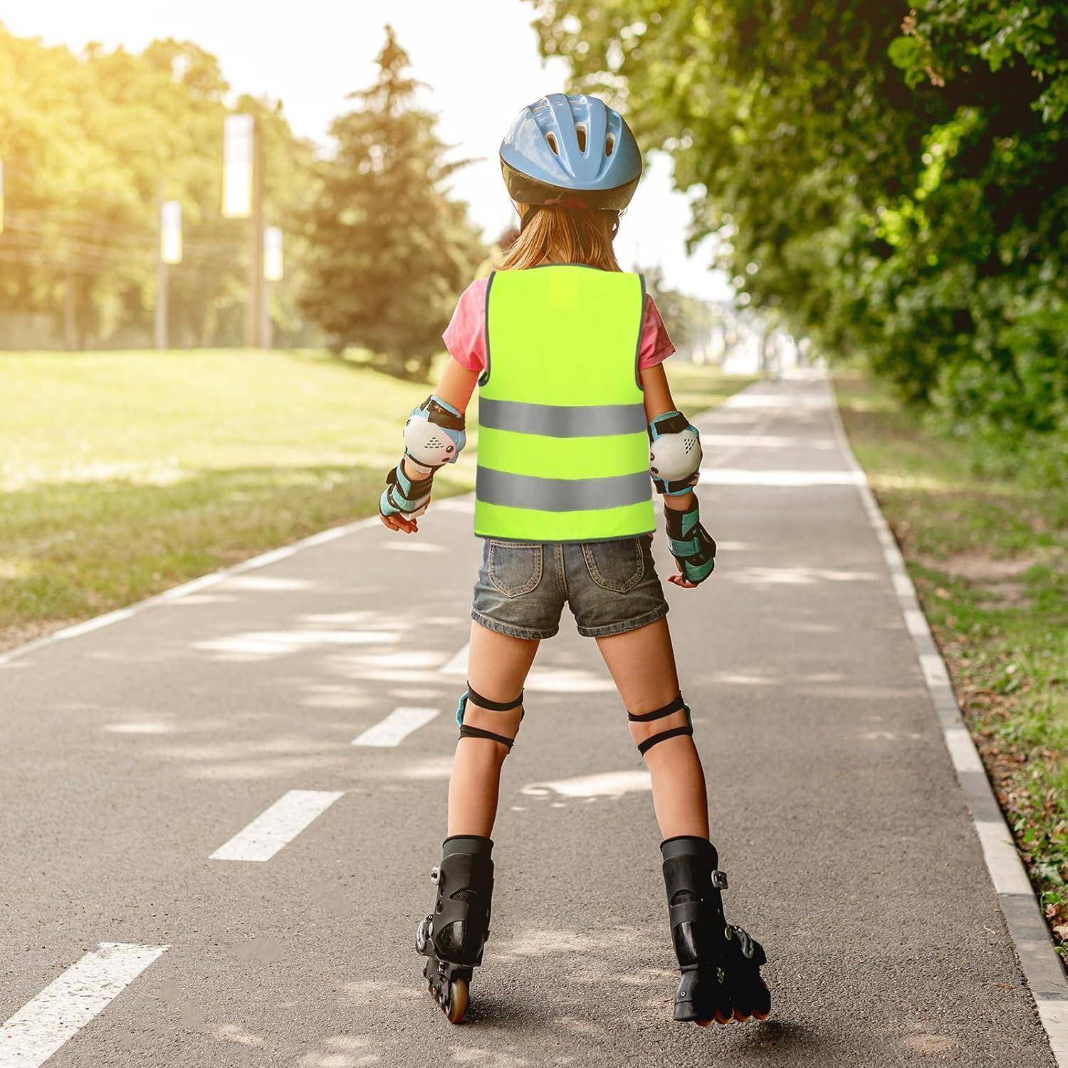 Kind mit Helm und Schutzausrüstung, das auf einem gepflasterten Parkweg Rollschuhe fährt, von hinten gesehen.