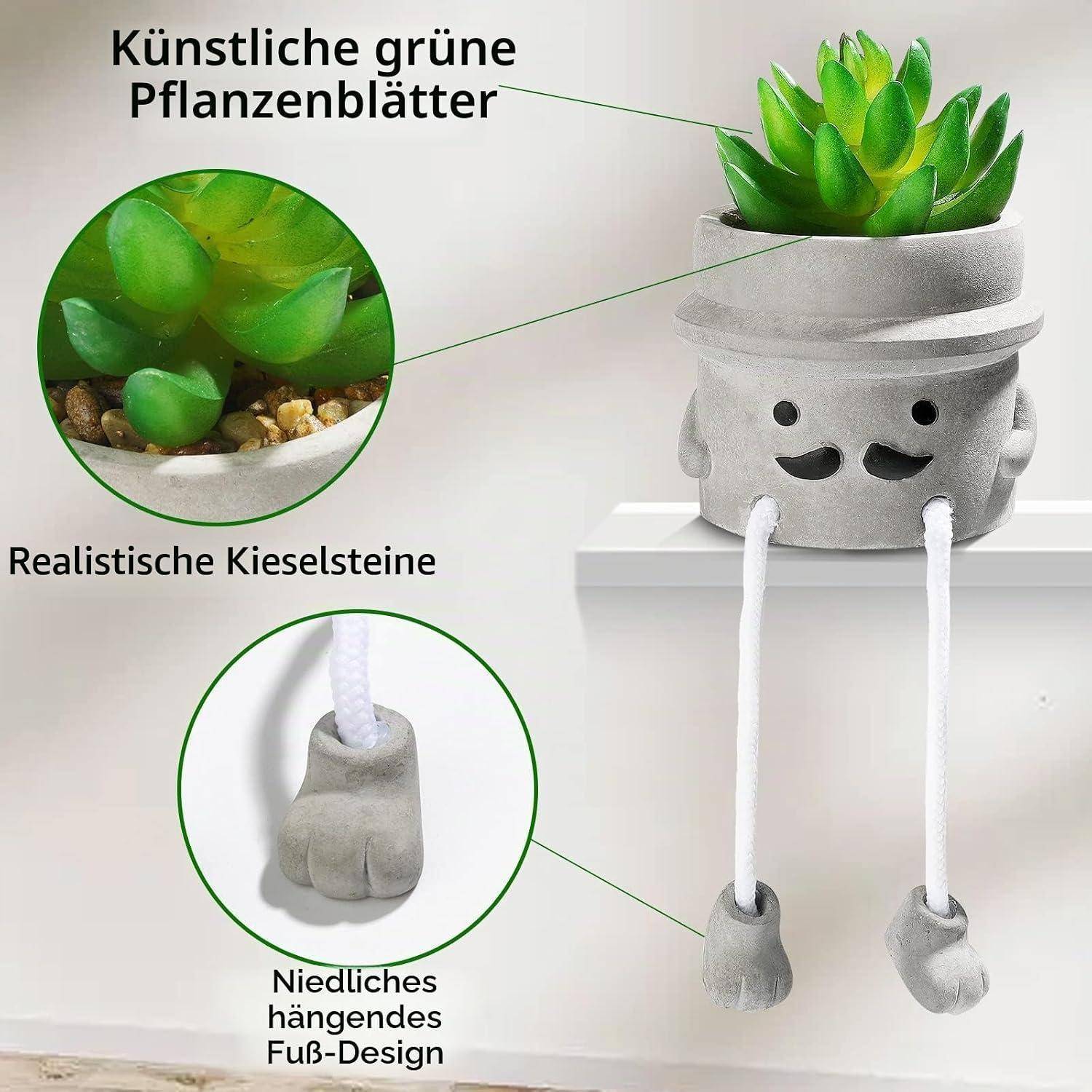 Produktbild eines niedlichen grauen hängenden Blumentopfs mit lachendem Gesicht, künstlichen grünen Blättern und baumelnden Beinen; Beschriftungen heben realistische Kieselsteine und Blattdetails hervor.