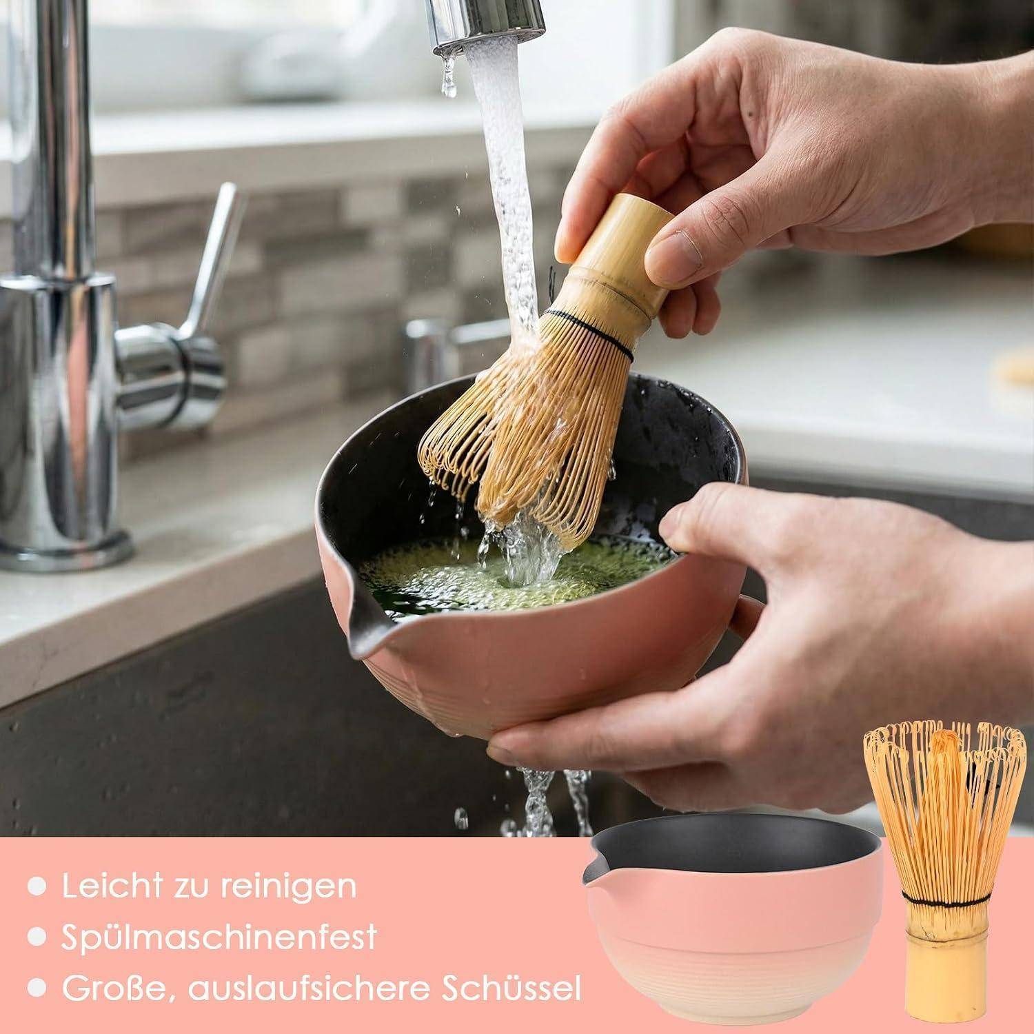 Hände spülen einen Bambus-Matcha-Quirrl in einer rosa Schüssel unter einem Küchenarmatur ab; der Text hebt einfache Reinigung, Spülmaschinenfestigkeit und eine große auslaufsichere Schüssel hervor.