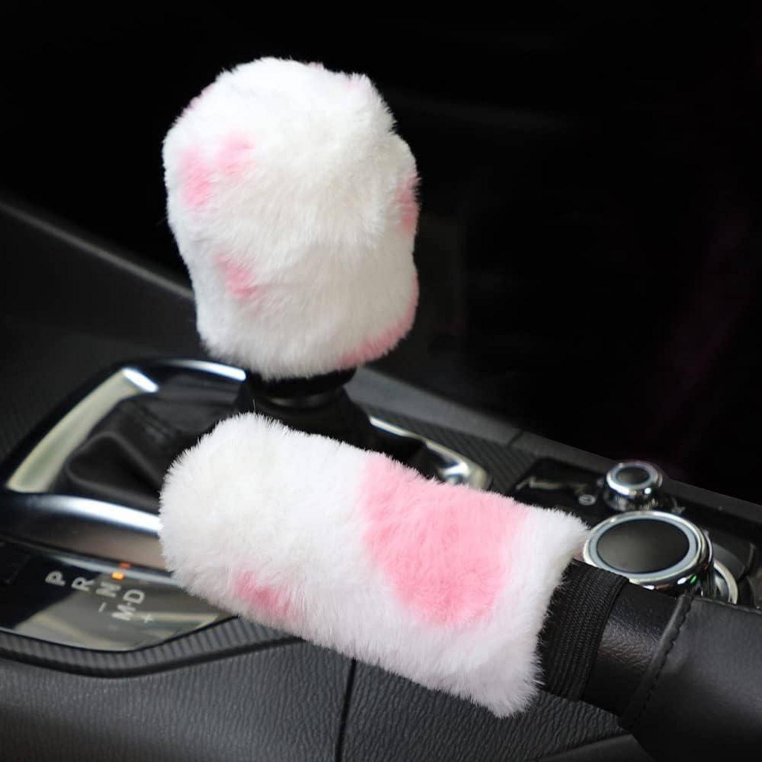 Schalthebel und Handbremse des Autos mit weißem flauschigem Kunstfell überzogen, mit rosa Flecken, in der mittleren Mittelkonsole eines Autos.
