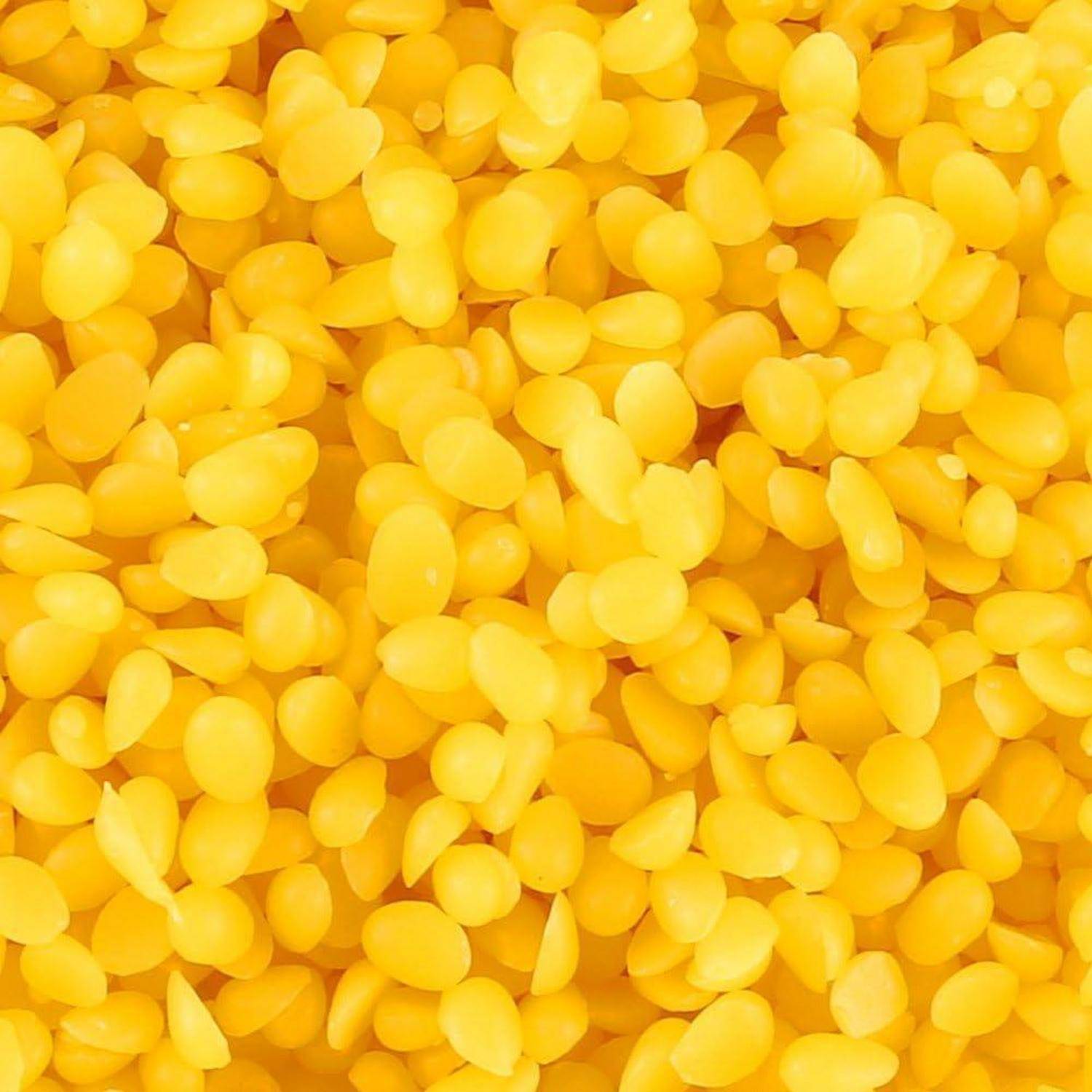 Nahaufnahme von vielen kleinen, leuchtend gelben bohnen- oder samenähnlichen Stücken, die das Bild ausfüllen.