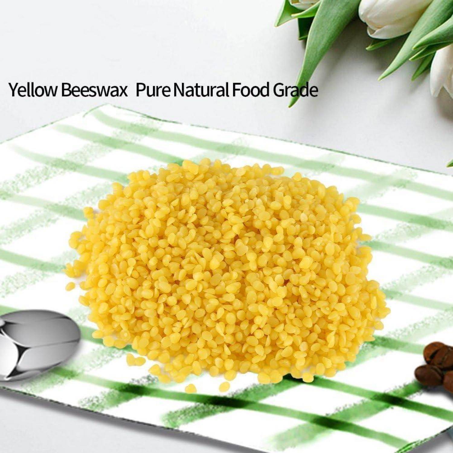 Haufen gelber Bienenwachspellets auf einem grün gestreiften Tuch, beschriftet mit „Yellow Beeswax Pure Natural Food Grade