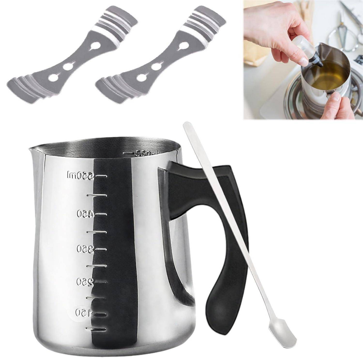 Edelstahlkrug mit schwarzem Griff und Messskalen, gezeigt mit zwei Rührern und einem kleinen Ausschnitt von aufgeschäumter Milch für Kaffee.