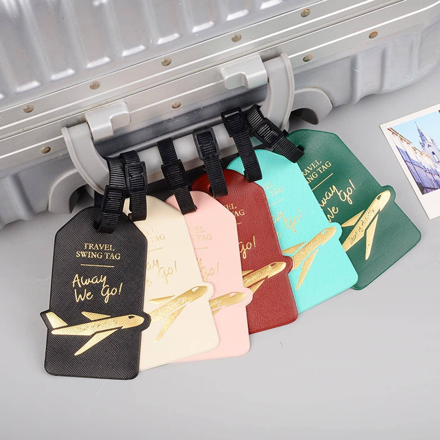 Bunte Gepäckanhänger, die an einem Koffergriff befestigt sind, mit den Aufschriften „Travel swing tag" und „Away We Go!"" sowie Flugzeuggrafiken.