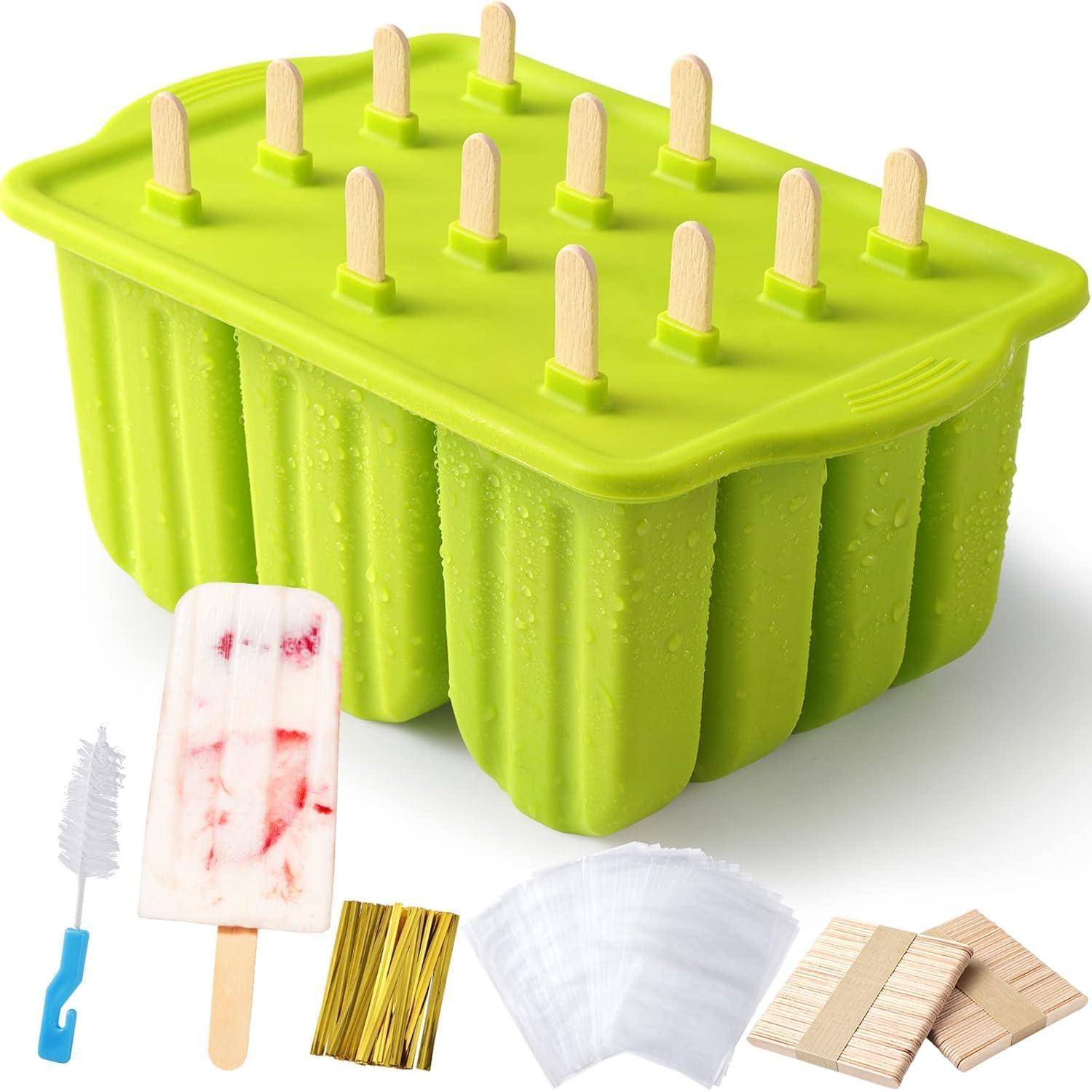 Grüne rechteckige Eis am Stiel-Form mit 12 Holzstäbchen und mitgelieferter Reinigungsbürste, Rührstäbchen, Filtern und Holzstab-Packungen darunter angezeigt.