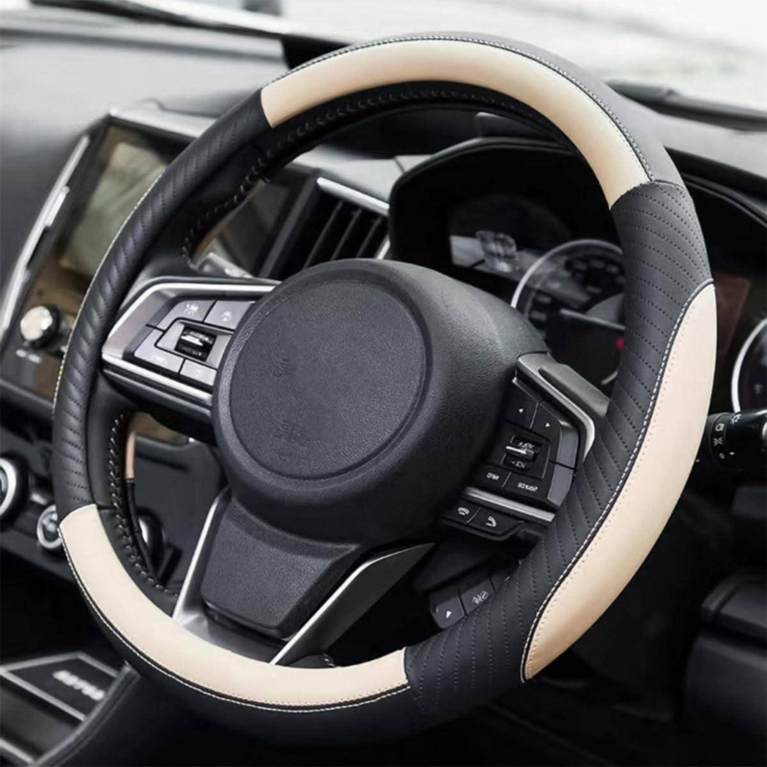 Nahaufnahme eines schwarz-beige Autolenkrads mit integrierten Steuertasten im Inneren eines modernen Fahzeuginnenraums.