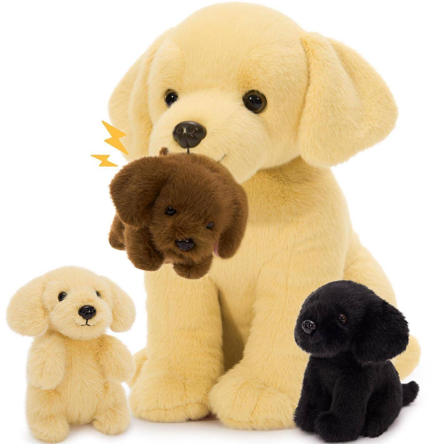 Drei kuschelige Hundespielzeuge auf weißem Hintergrund, wobei ein großer cremefarbener Welpe einen kleinen braunen Welpen im Maul hält, und kleinere cremefarbene und schwarze Welpen daneben.
