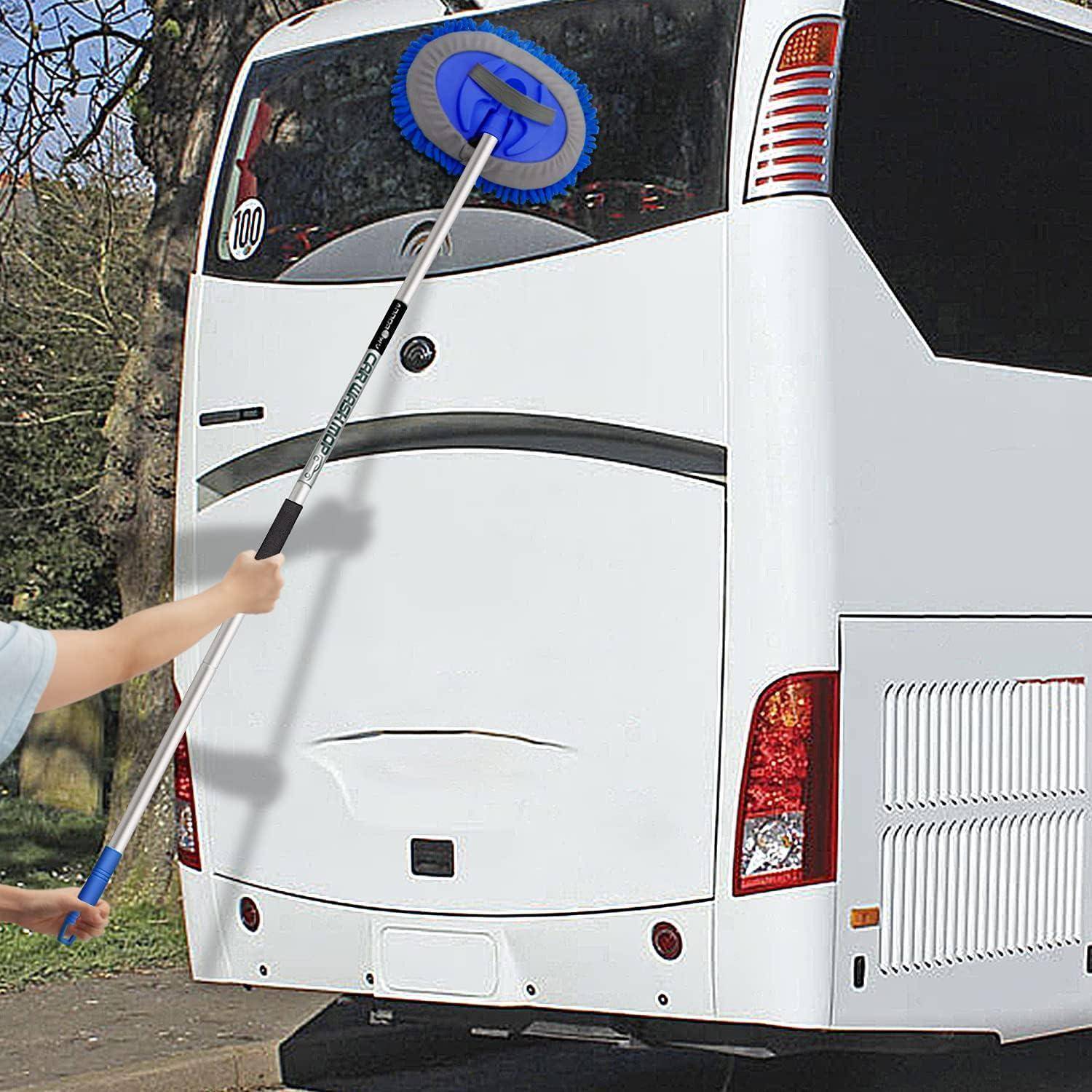 Eine Person reinigt mit einer Bürste mit langem Stiel die Heckscheibe und den oberen hinteren Teil eines weißen Busses im Freien.