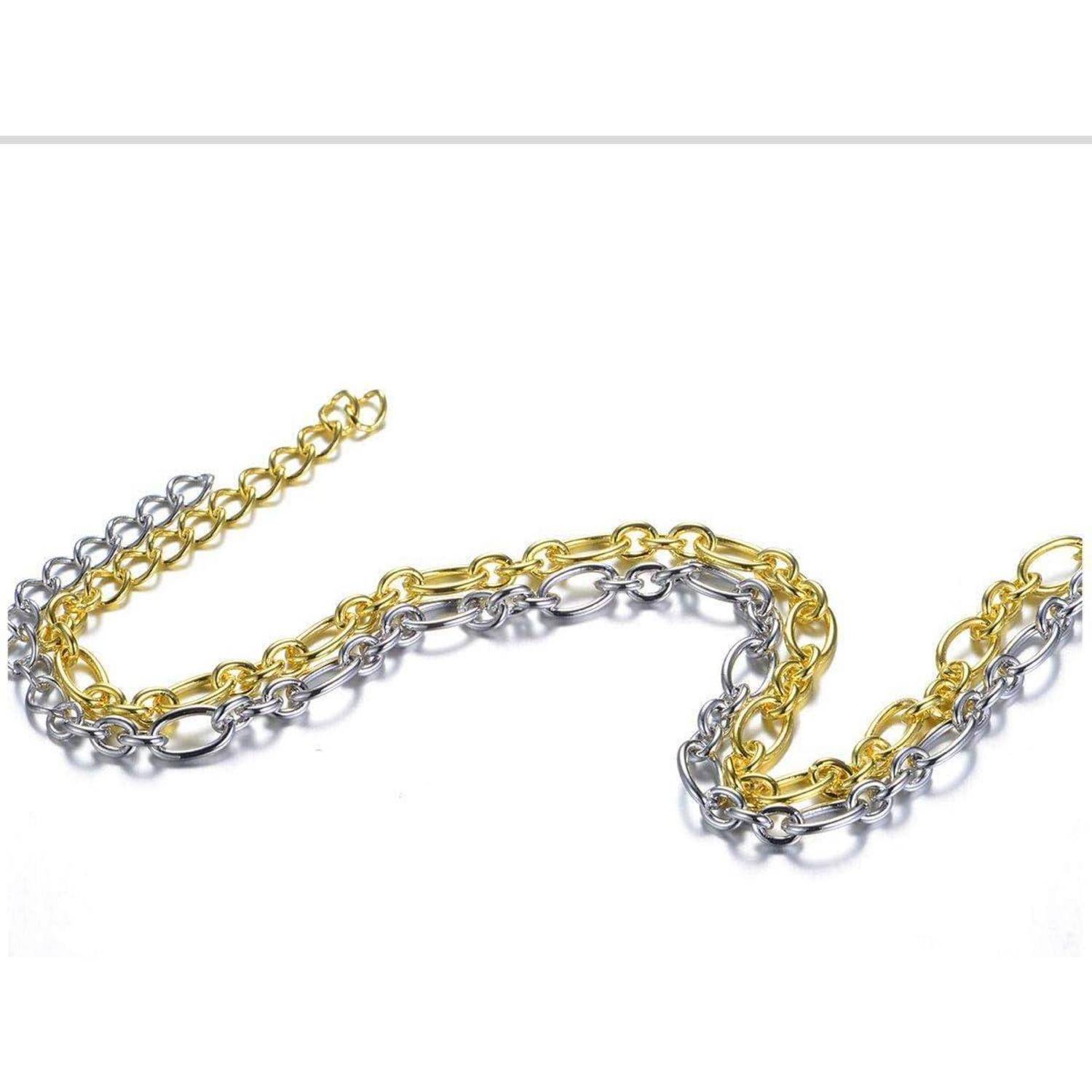 Verschlungene Gold- und Silberkettenkette in einer Wellenlinie auf weißem Hintergrund angeordnet.