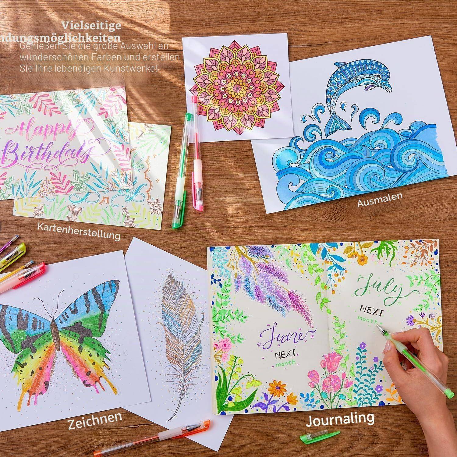 Kreative Aktivitätsbeispiele auf einem Holztisch: Geburtstagskarten, Schmetterlingszeichnung, Mandala und Delphin ausmalen sowie Juli-Tagebuch.