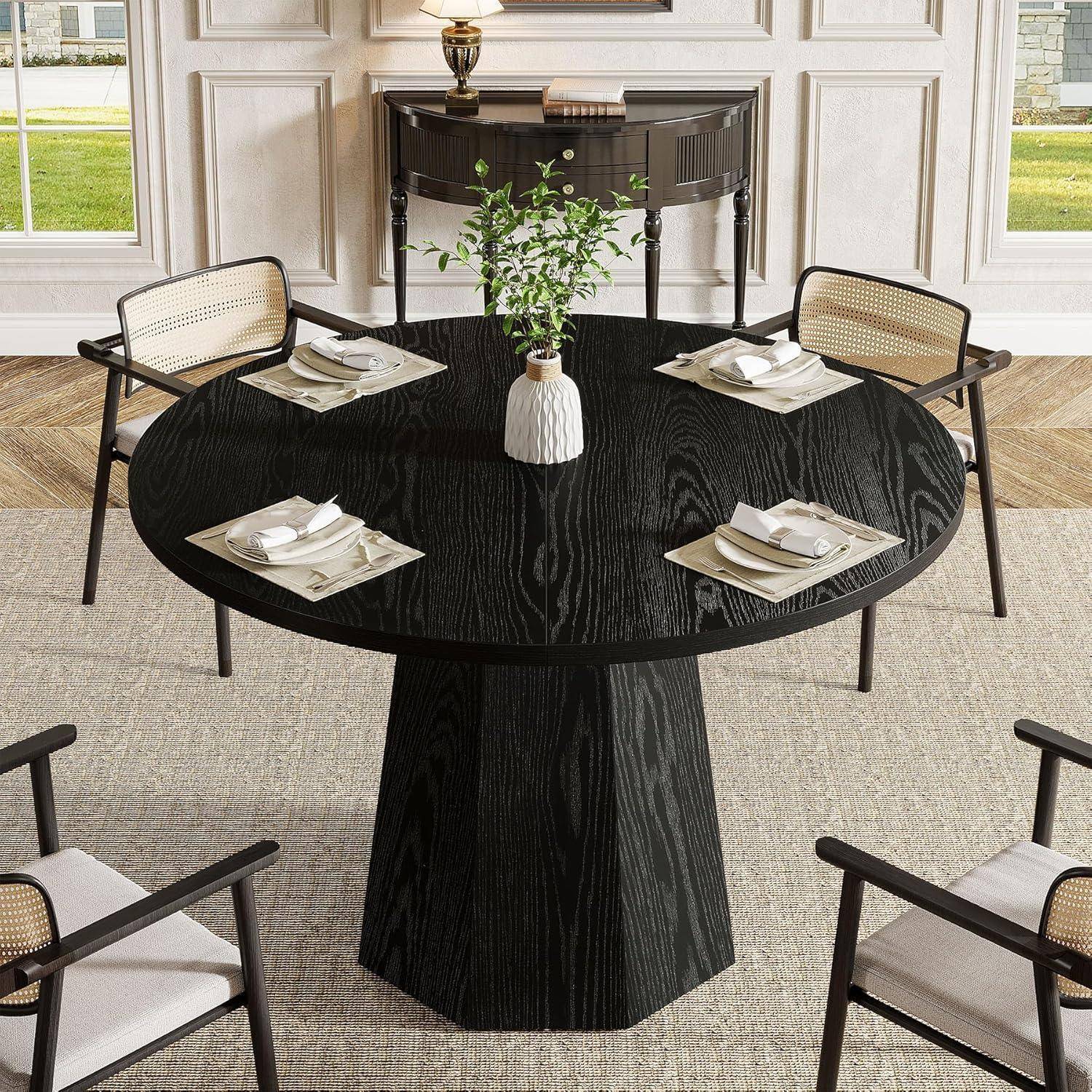 Modernes Esszimmer mit einem runden schwarzen Tisch für vier Personen, beigen Stühlen und einer kleinen Vasencenterpiece in der Nähe eines Konsolentisches und Fenster.