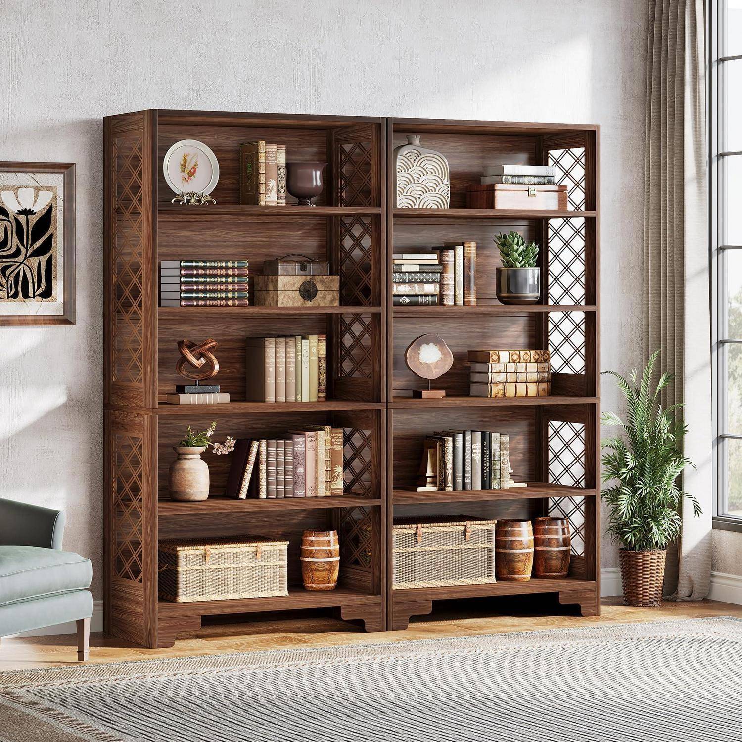 Zwei hohe Bücherregale aus dunklem Holz mit Büchern, Körben, Dekorationen und Pflanzen in einem hellen Wohnzimmer.