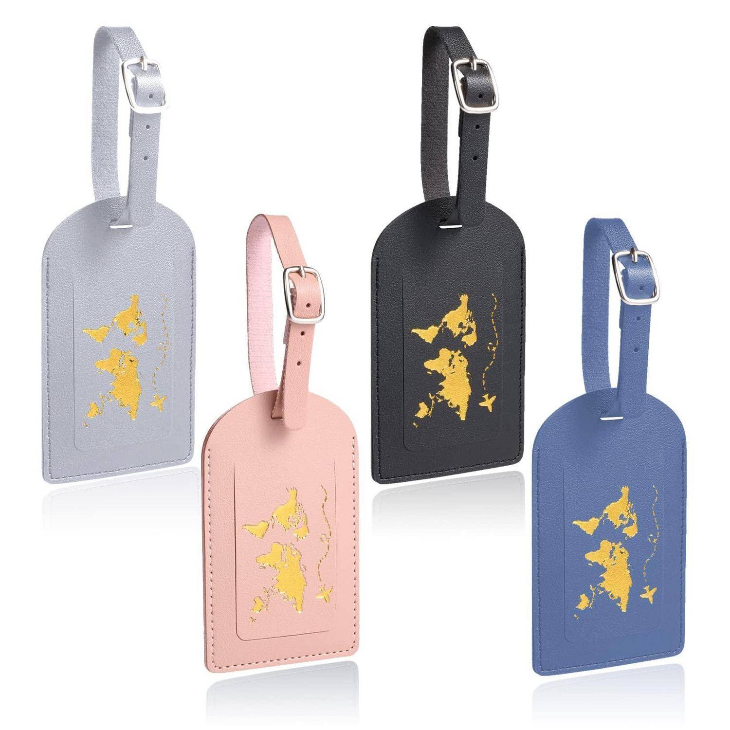 Vier Lederkoffer-Anhänger in Grau, Rosa, Schwarz und Blau mit goldenen kartenähnlichen Designs und Schnallriemen, auf weißem Hintergrund dargestellt.