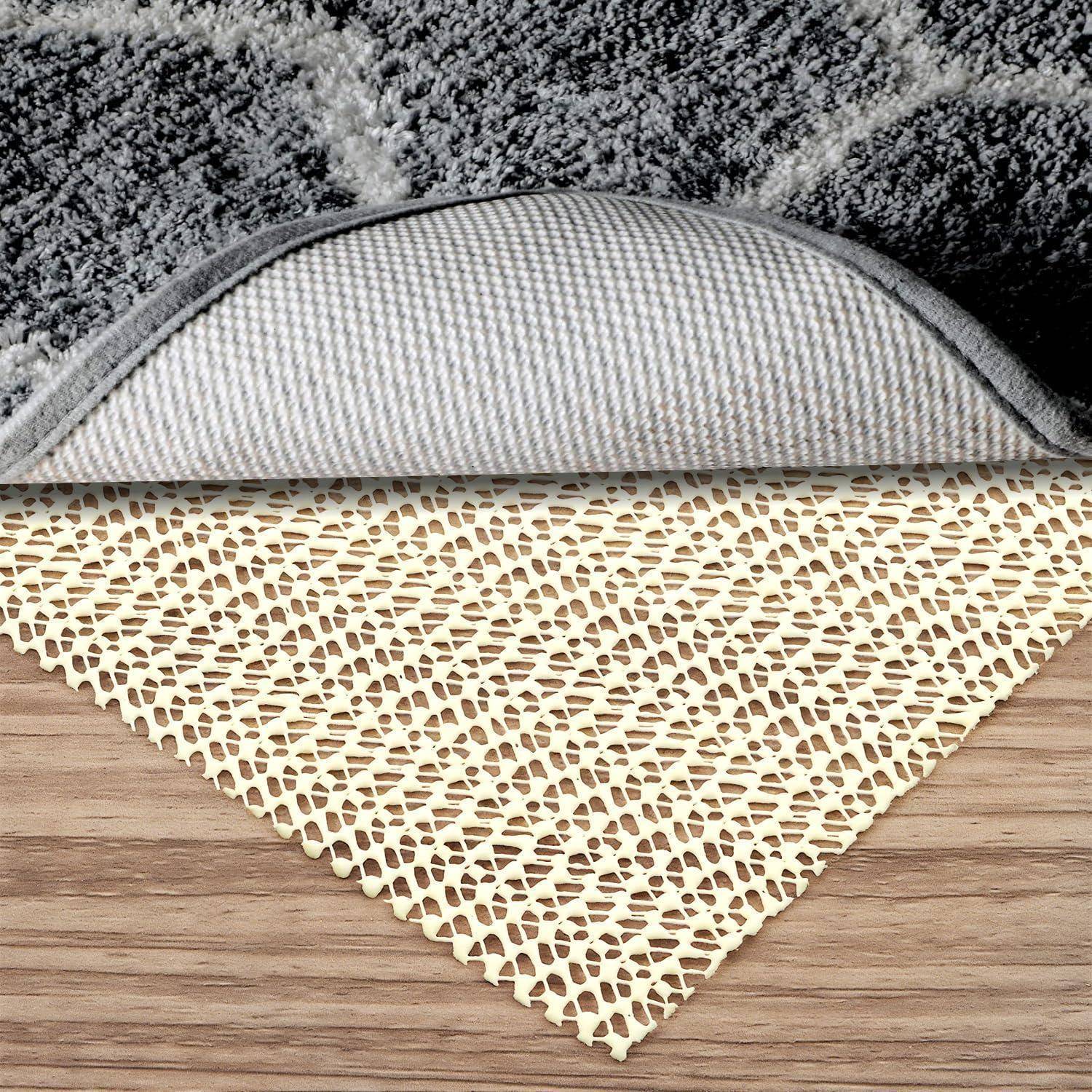 Ecke eines Teppichs angehoben, um die gummierte, strukturierte Unterseite und eine beige Netzunterlage auf einem Holzboden zu zeigen.