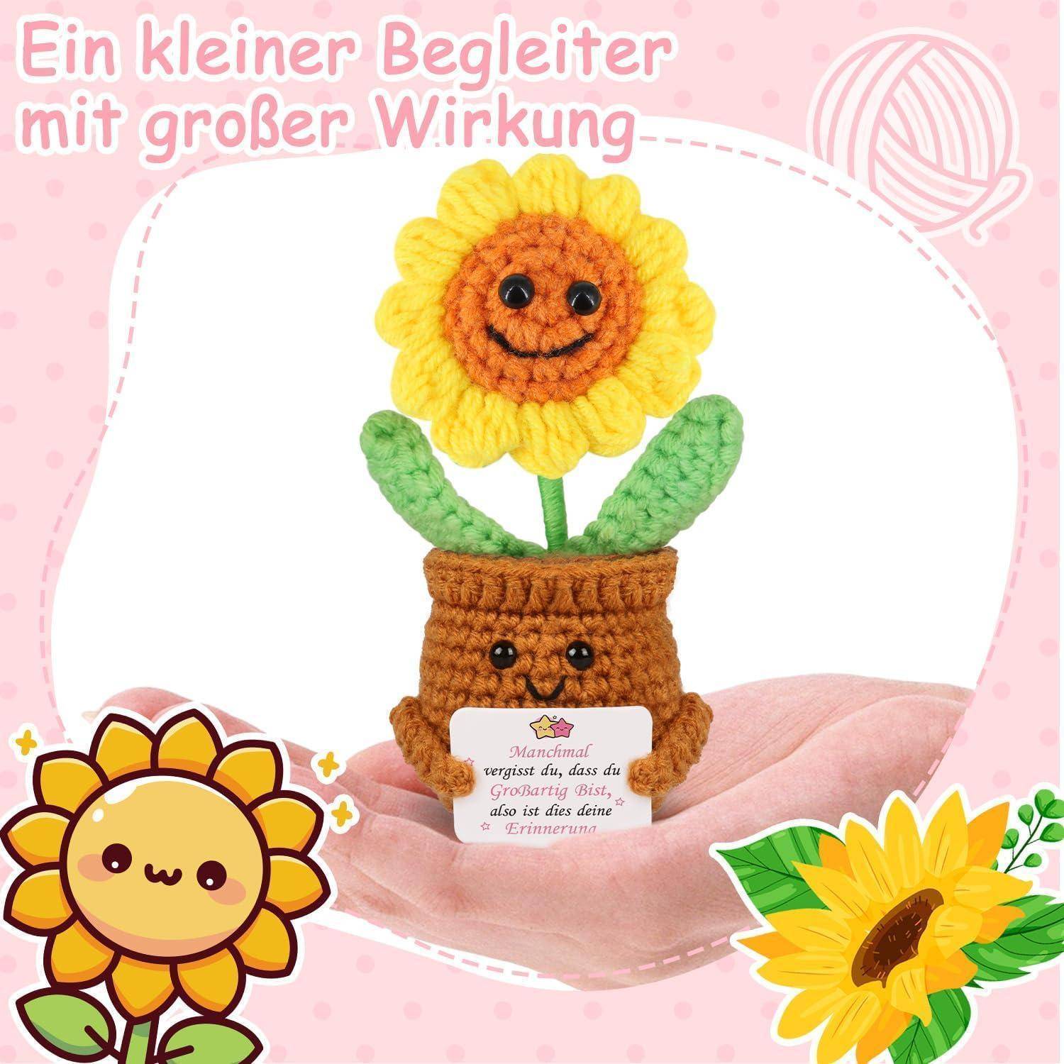 Gehäkeltes Sonnenblumen-Spielzeug in einem winzigen Topf, das in Händen gehalten wird, mit deutschem Text „Ein kleiner Begleiter mit großer Wirkung