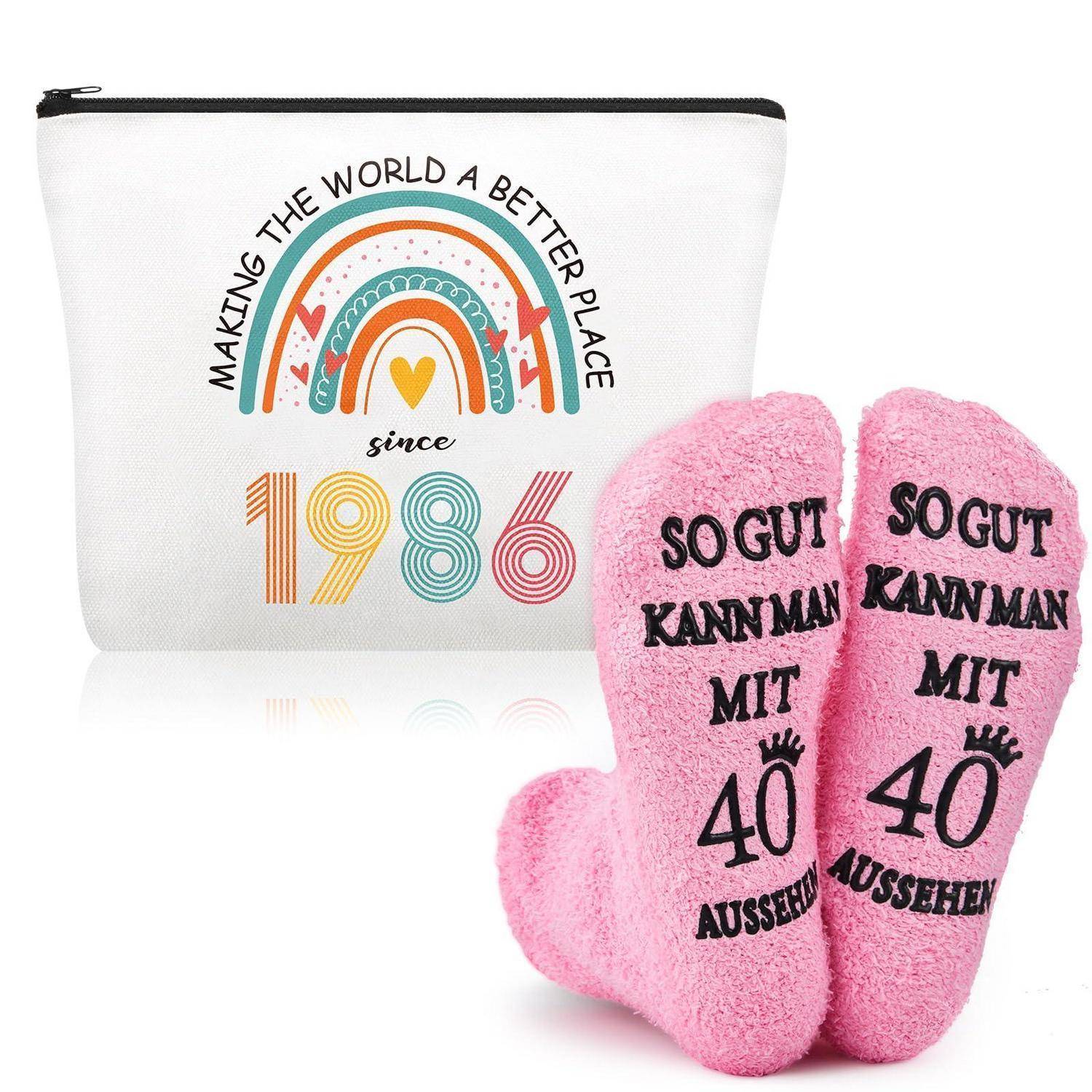 Rosa Novität-Socken neben einem weißen Beutel mit Regenbogendruck und dem Text „Die Welt seit 1986 zu einem besseren Ort machen