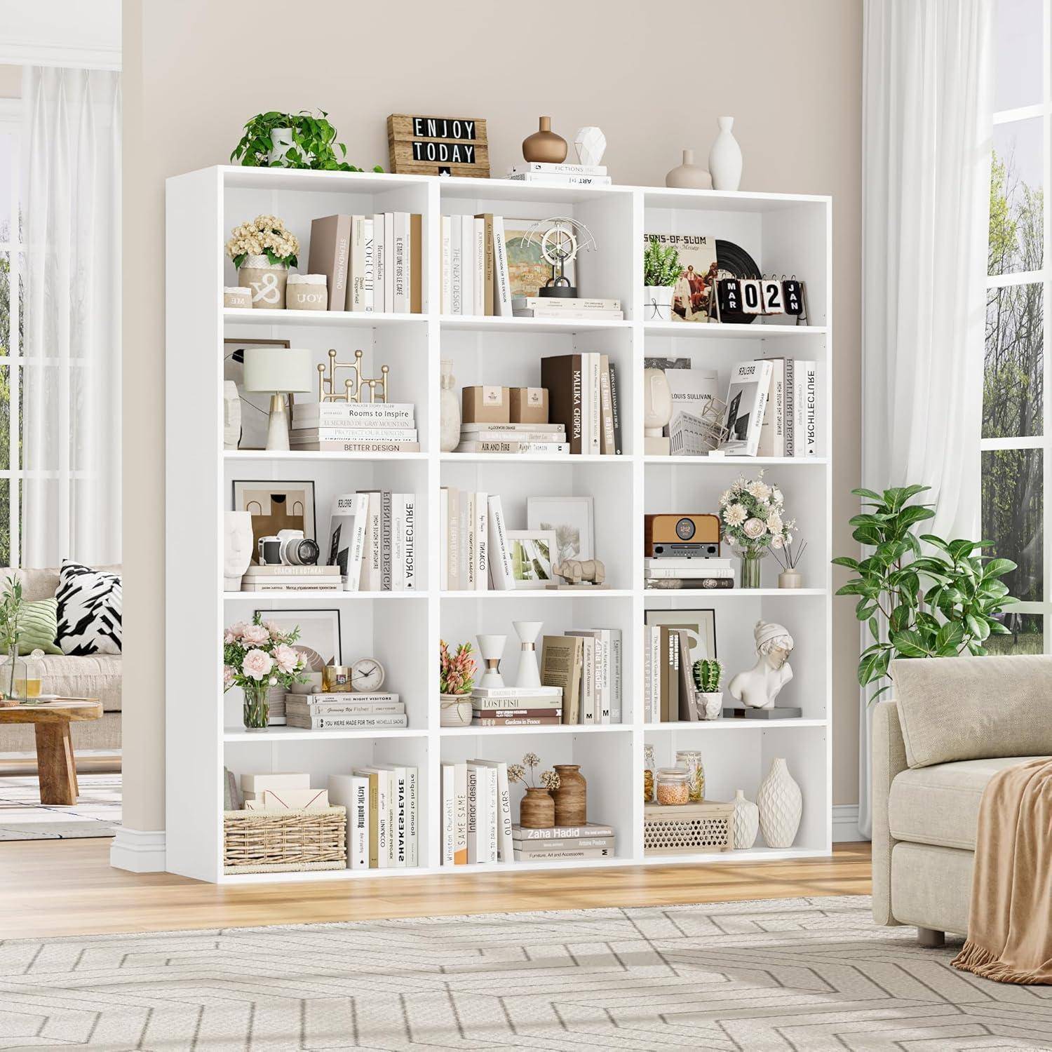 Weißes würfelförmiges Bücherregal gefüllt mit Büchern, Pflanzen, Vasen, Rahmenfotos und Dekoration in einem hellen Wohnzimmer neben einem Sofa und Fenster.