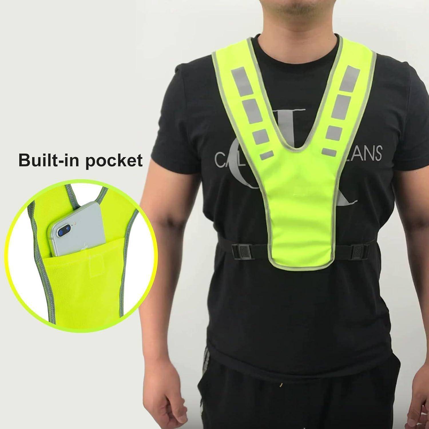 Person trägt eine neongelbe reflektierende Weste mit eingebauter Brusttasche; die Vergrößerung zeigt ein Telefon, das in der Tasche aufbewahrt ist.
