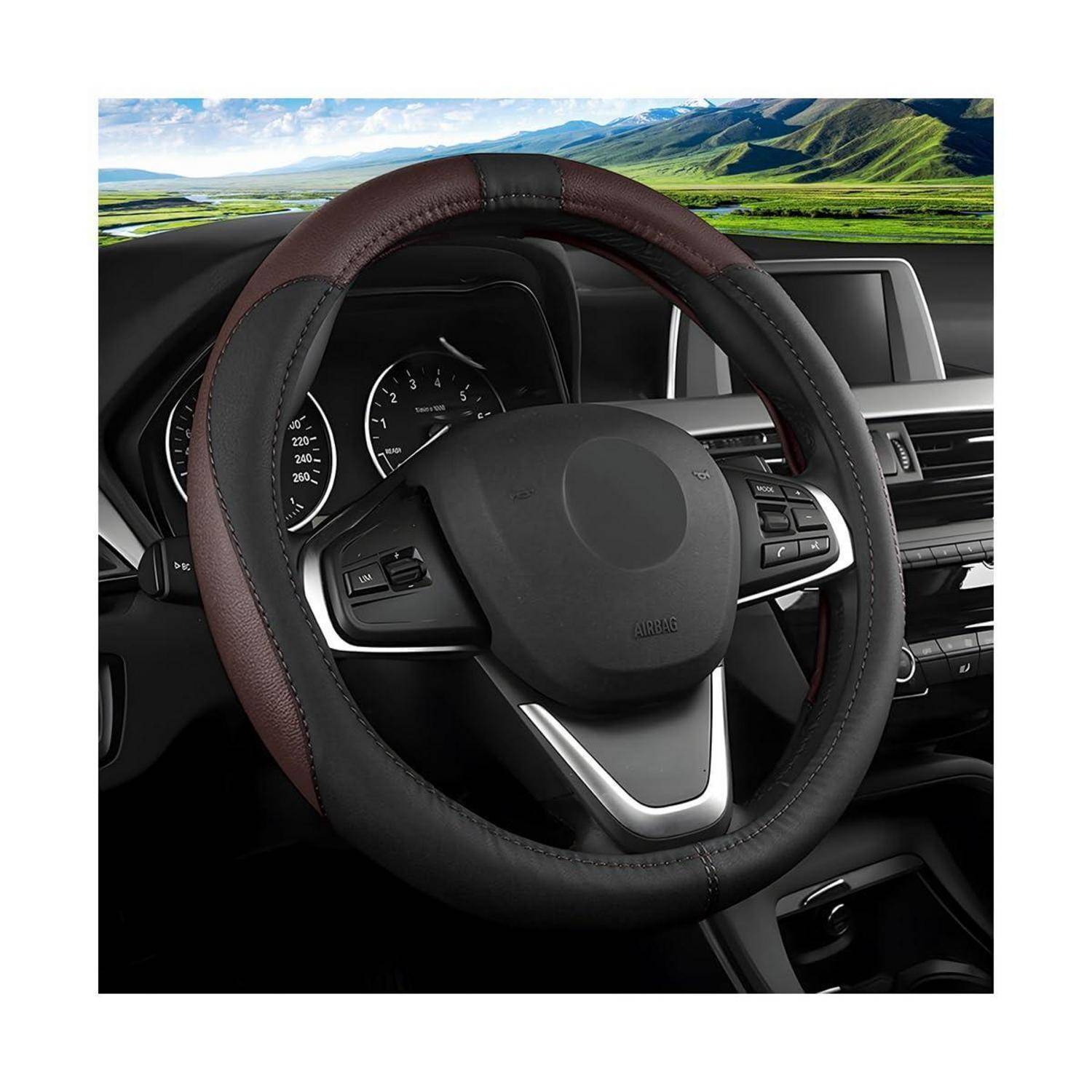 Nahaufnahme des Autoinnenraums mit einem schwarzen Lederlenkrad mit gestepptem Bezug, Armaturenbrett-Instrumenten und Mittelkonsole vor einer malerischen Windschutzscheiben-Aussicht.