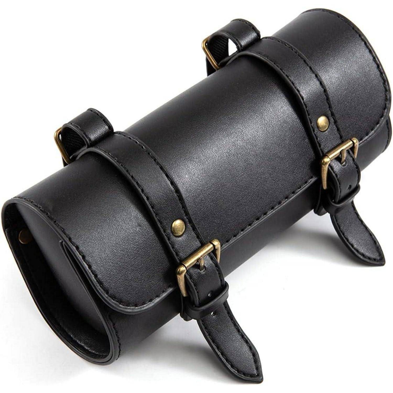 Schwarze zylindrische Ledertasche mit zwei Schnallengurten und Schlaufen, auf weißem Hintergrund gezeigt.