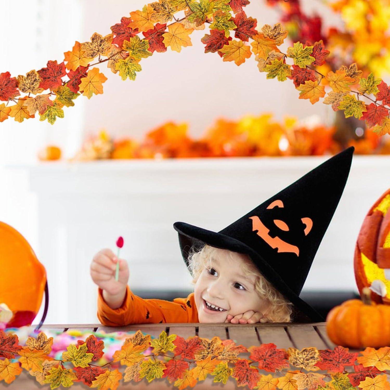 Lachendes Kind in einem schwarzen Hexenhut und orangefarbenem Hemd, das von einem Tisch aus hochgreift und einen Lutscher in einer Halloween-Szene mit Kürbissen und Herbstblättern hält.