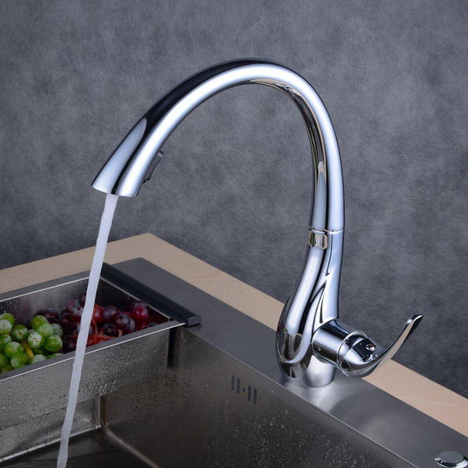 Chromeküchenarmatur mit fließendem Wasser in einem Spülbecken mit integriertem Obst- und Gemüsewaschbecken.