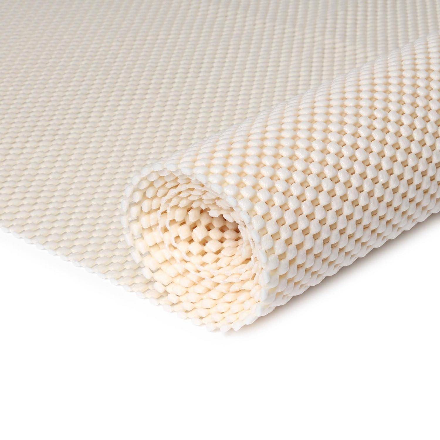 Aufgerollte beige strukturierte rutschfeste Matte oder Teppich mit einem gewebten Wabenmuster auf weißem Hintergrund.