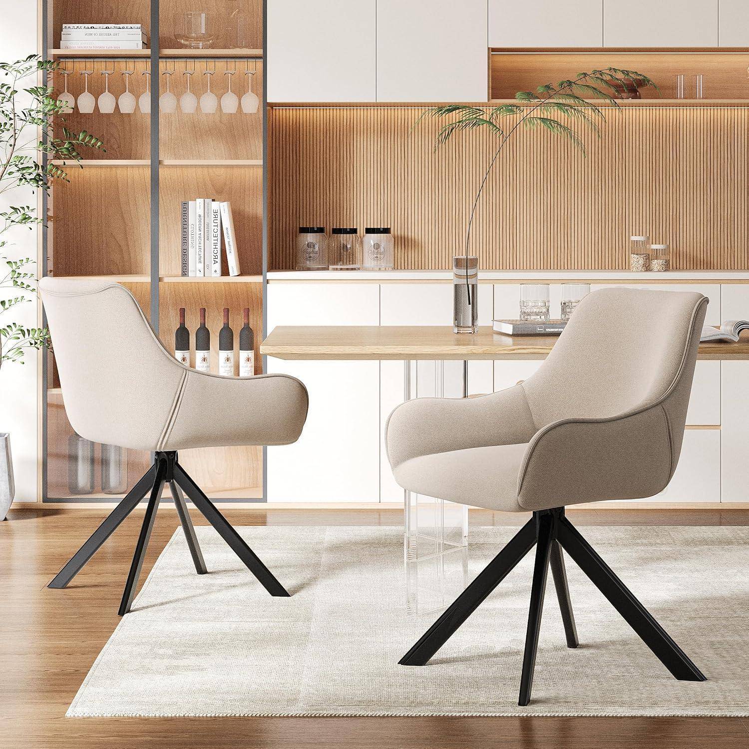 Moderner Essbereich mit zwei beigen Drehstühlen um einen Tisch aus hellem Holz, positioniert vor eingebautem Holzregal und minimalistische Küchenkulisse im Hintergrund.