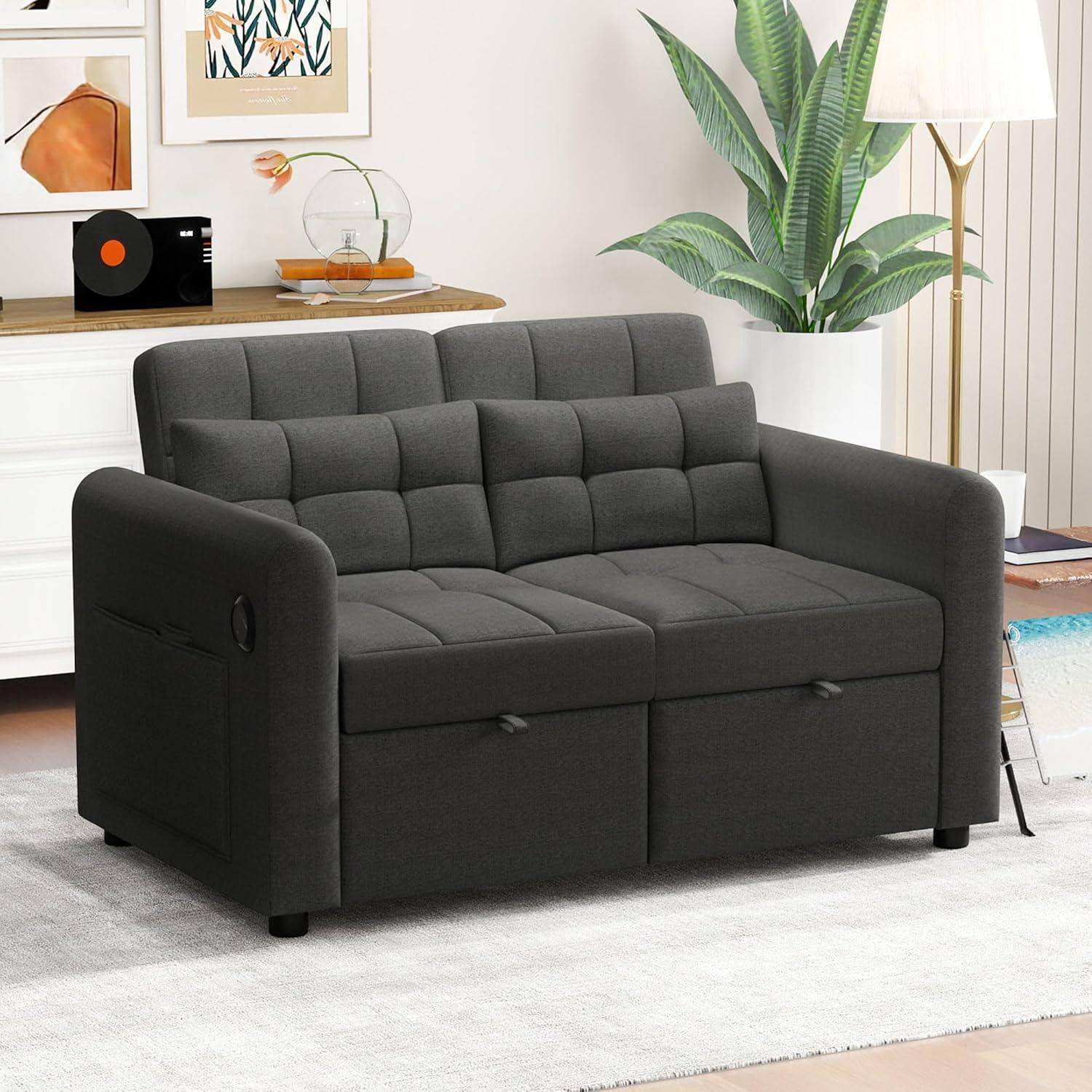 Dunkelgraues 2-Sitzer-Schlafsofa mit gepolsterter Rückenlehne und integriertem seitlichen Getränkehalter in einem hellen Wohnzimmer.