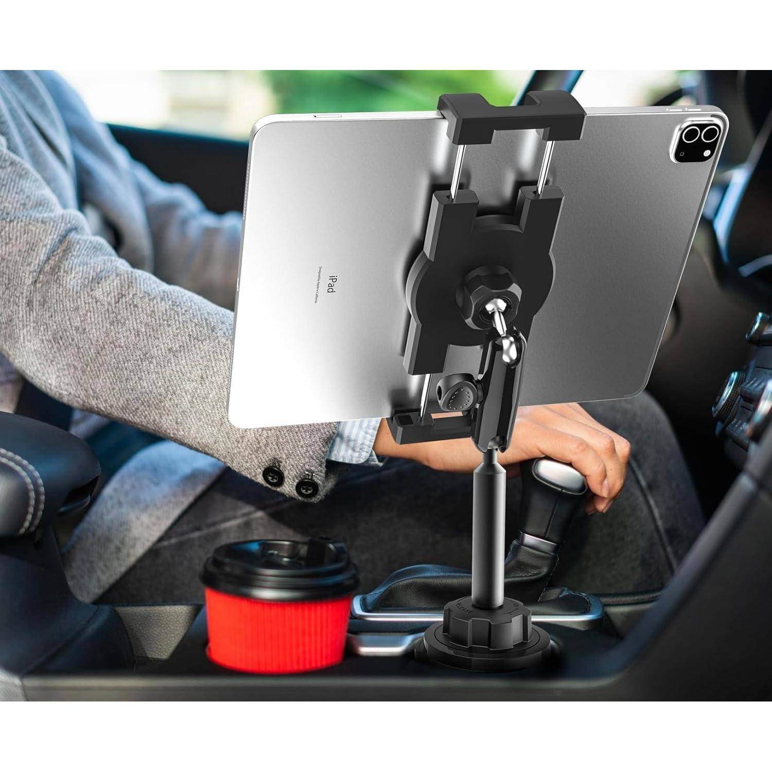 Tablet, das auf einem verstellbaren Mittelkonsolenhalter in einem Auto montiert ist, mit einem Fahrer, der die Schaltkulisse benutzt, und einem sichtbaren Getränkehalter.